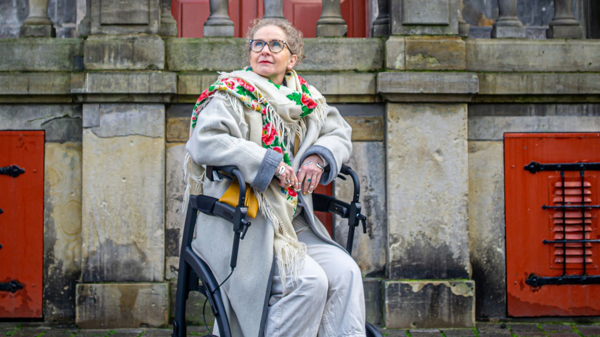 a woman sitting in a chair in front of a building
