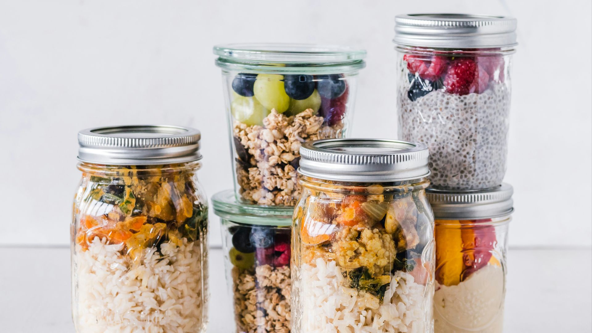 six full clear glass jars on white surface