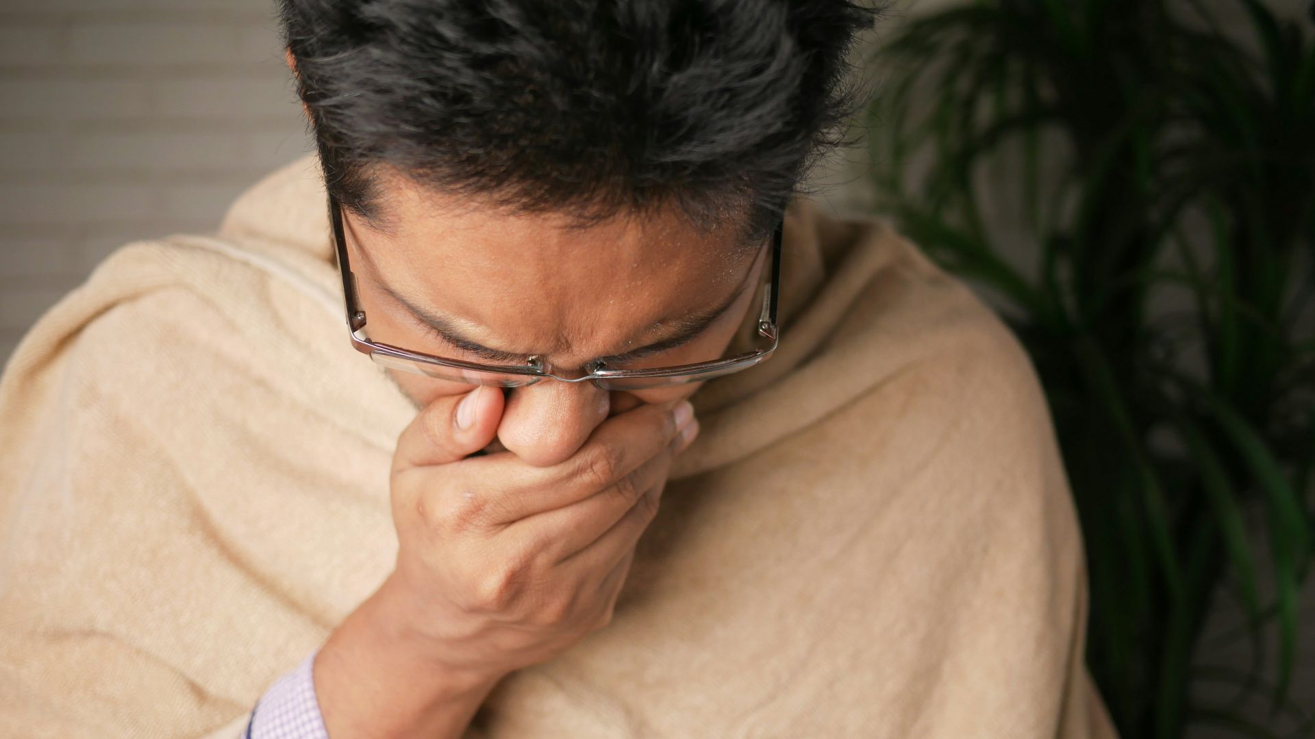 man in brown sweater wearing black framed eyeglasses
