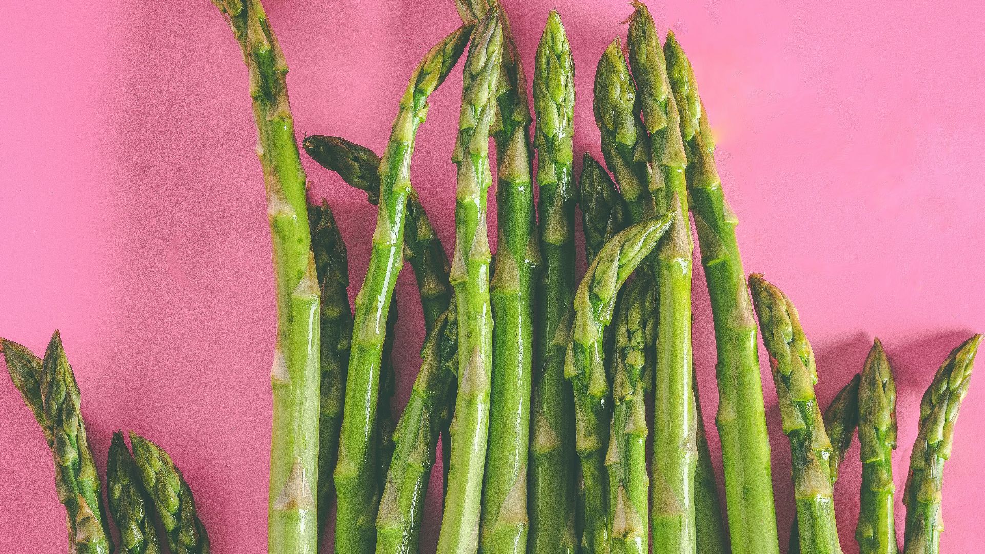 green asparagus vegetables on pink surface