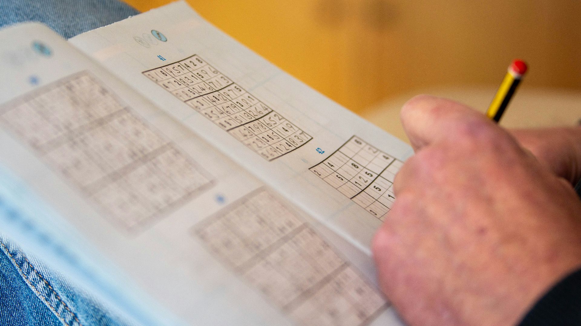 a person is holding a piece of paper with numbers on it