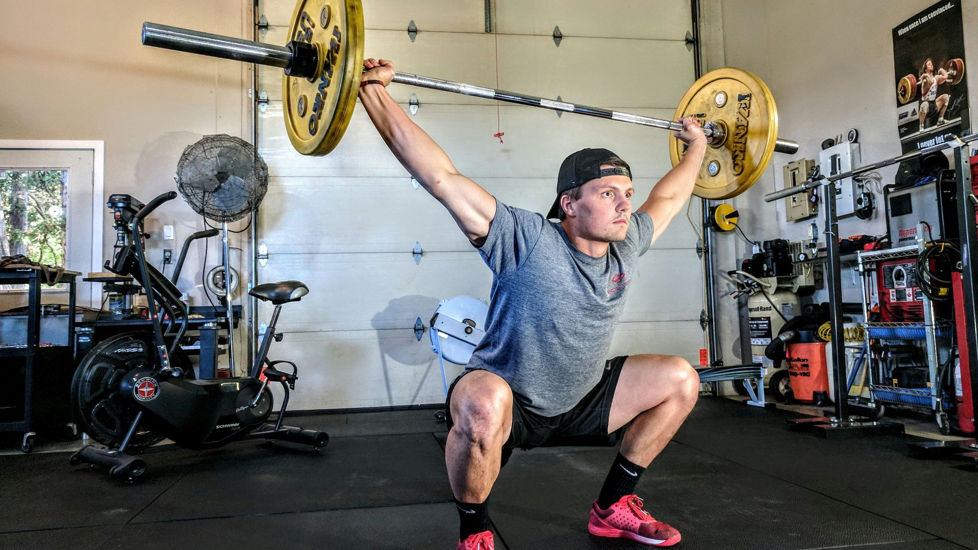 man lifting yellow barbell
