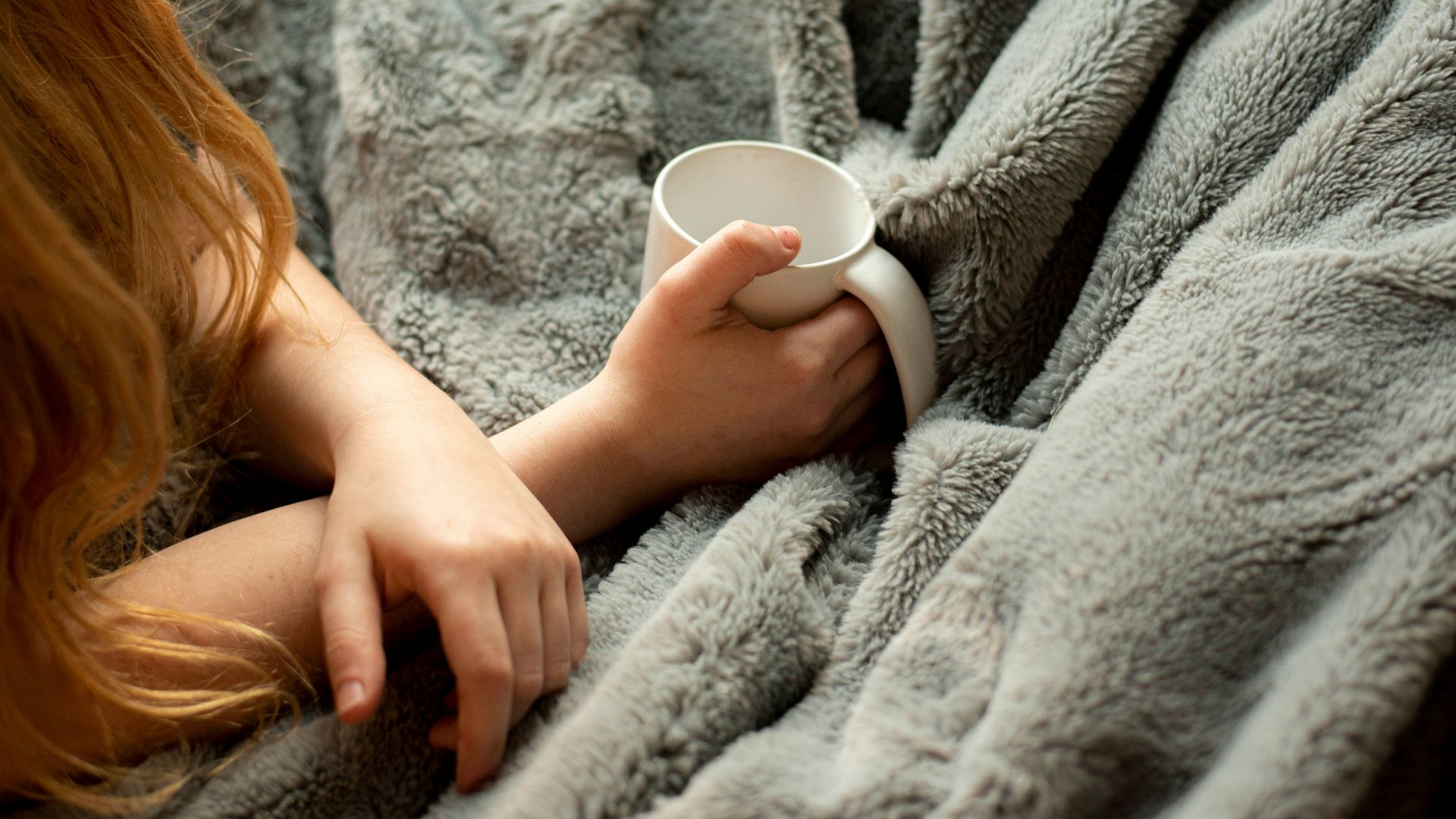 woman holding white ceramic mug