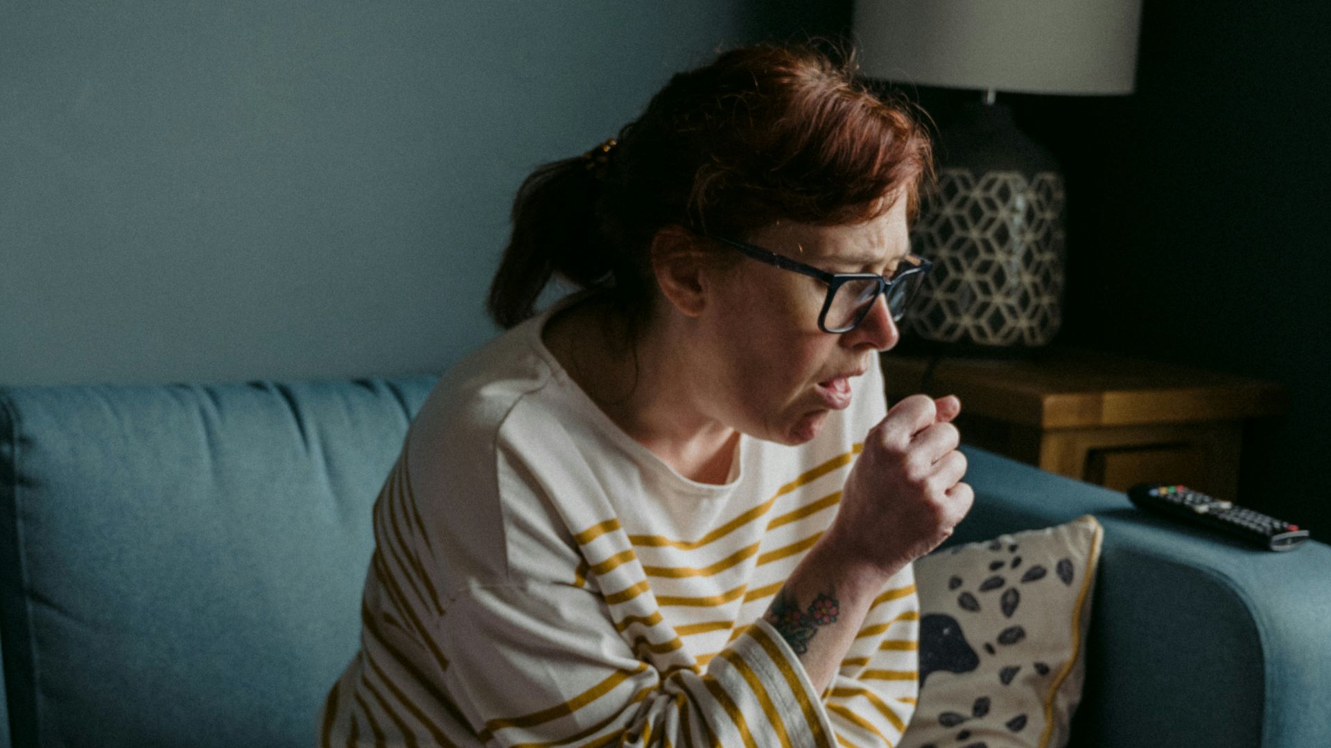 woman in white crew neck t-shirt sitting on gray sofa