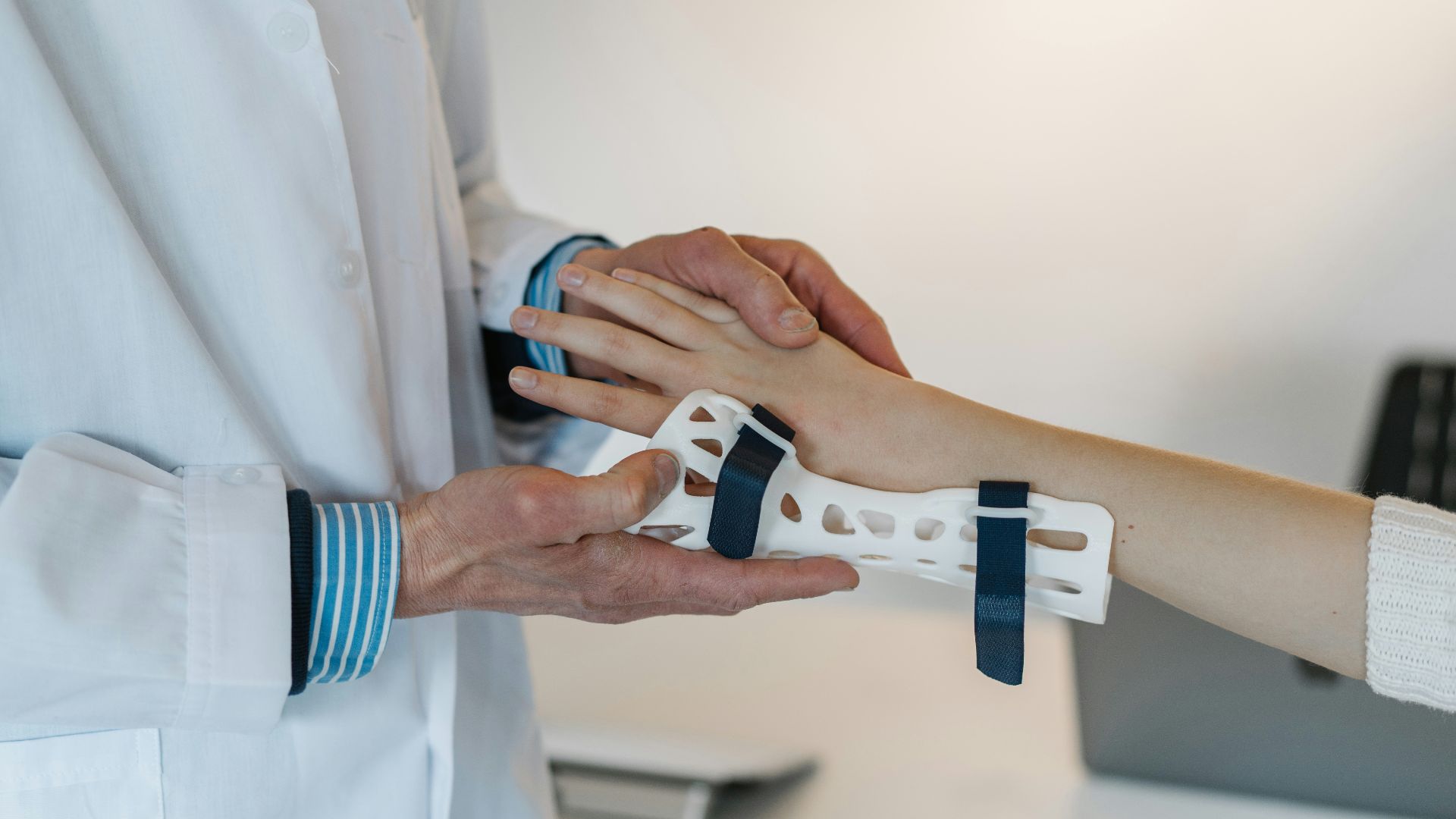 person in white coat holding silver and blue ring