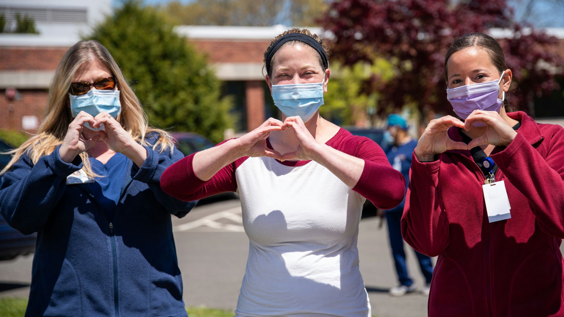 woman in white tank top and blue denim jeans holding woman in blue long sleeve shirt
