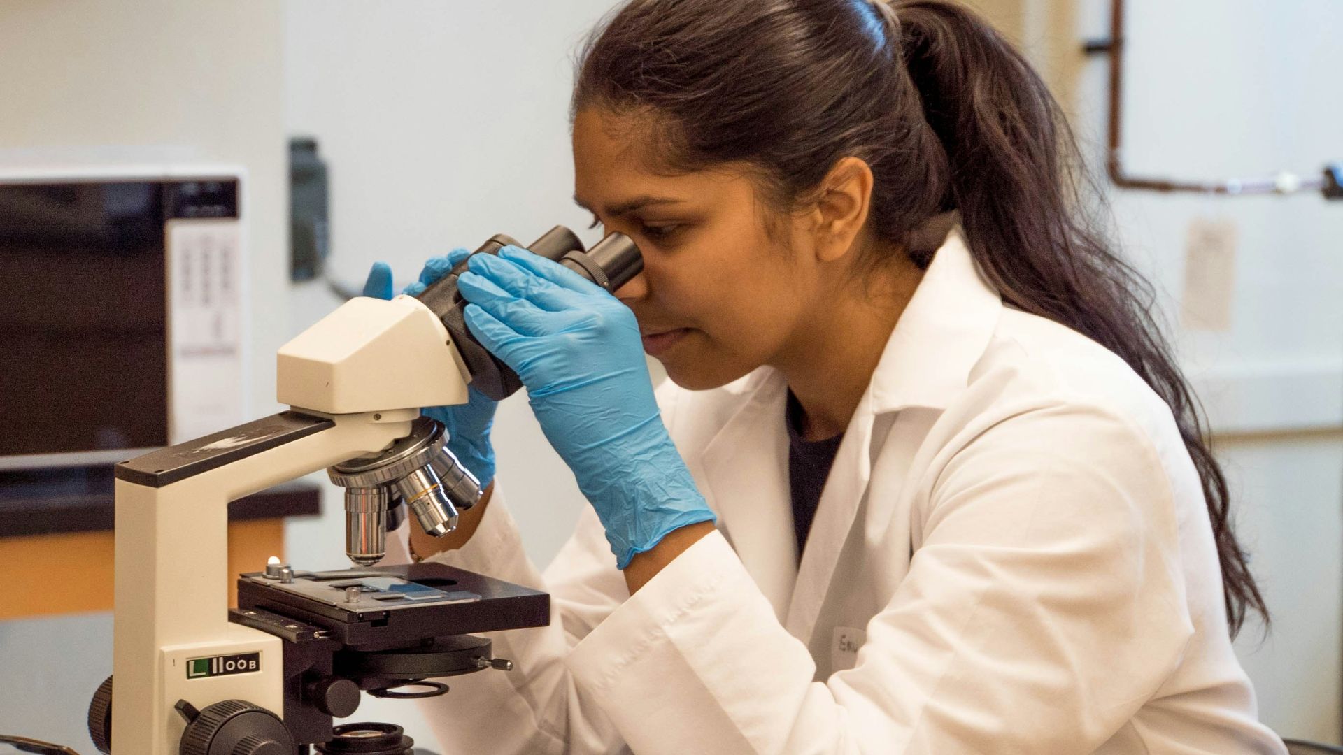 woman looking on microscope inside room