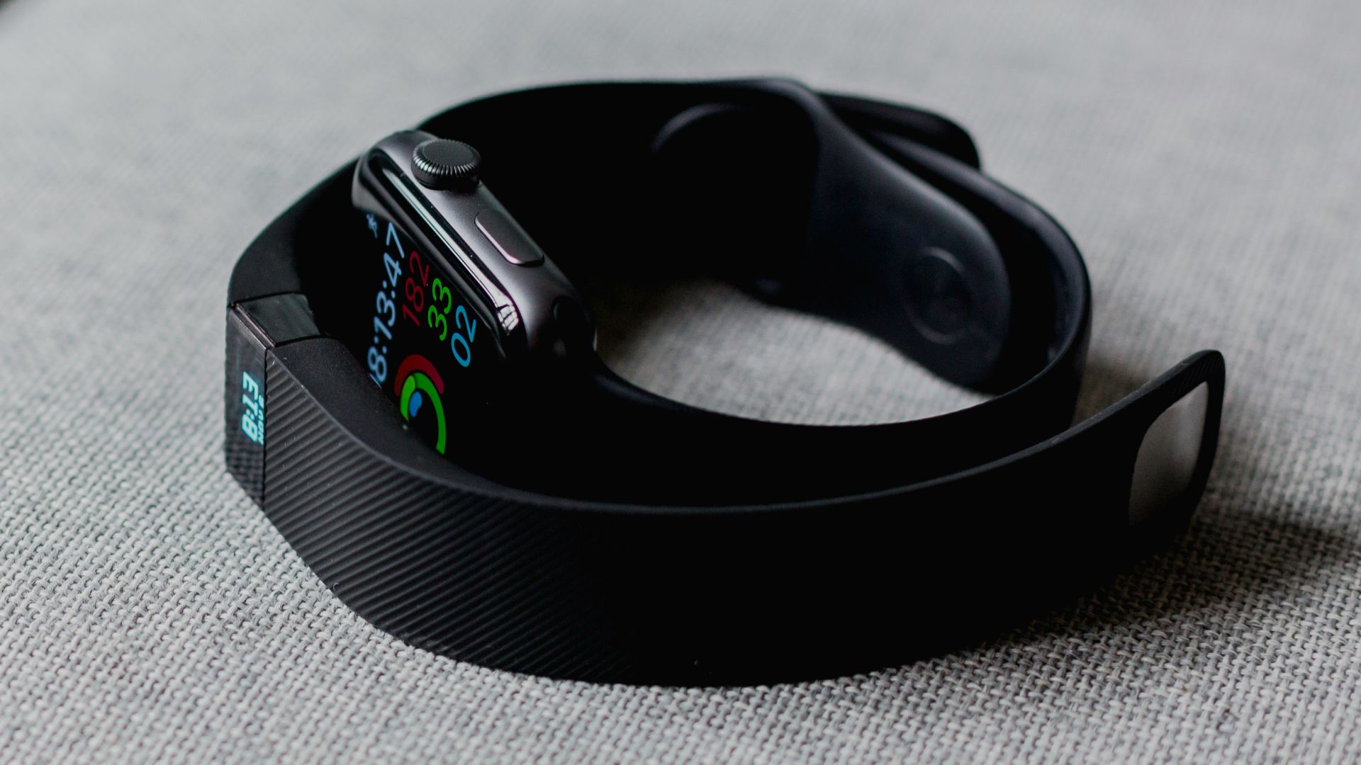 black aluminum case Apple Watch and black Fitbit charge 2