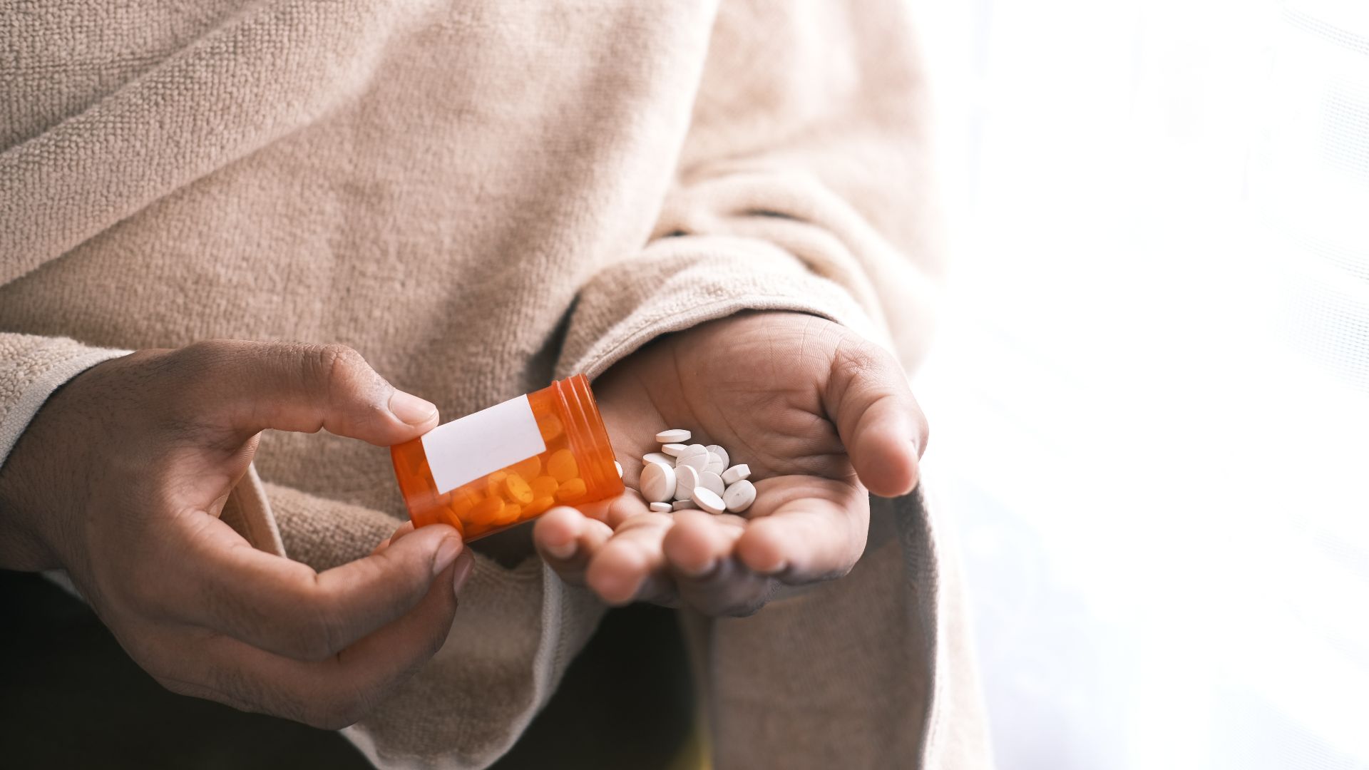 orange and white plastic bottle on white textile