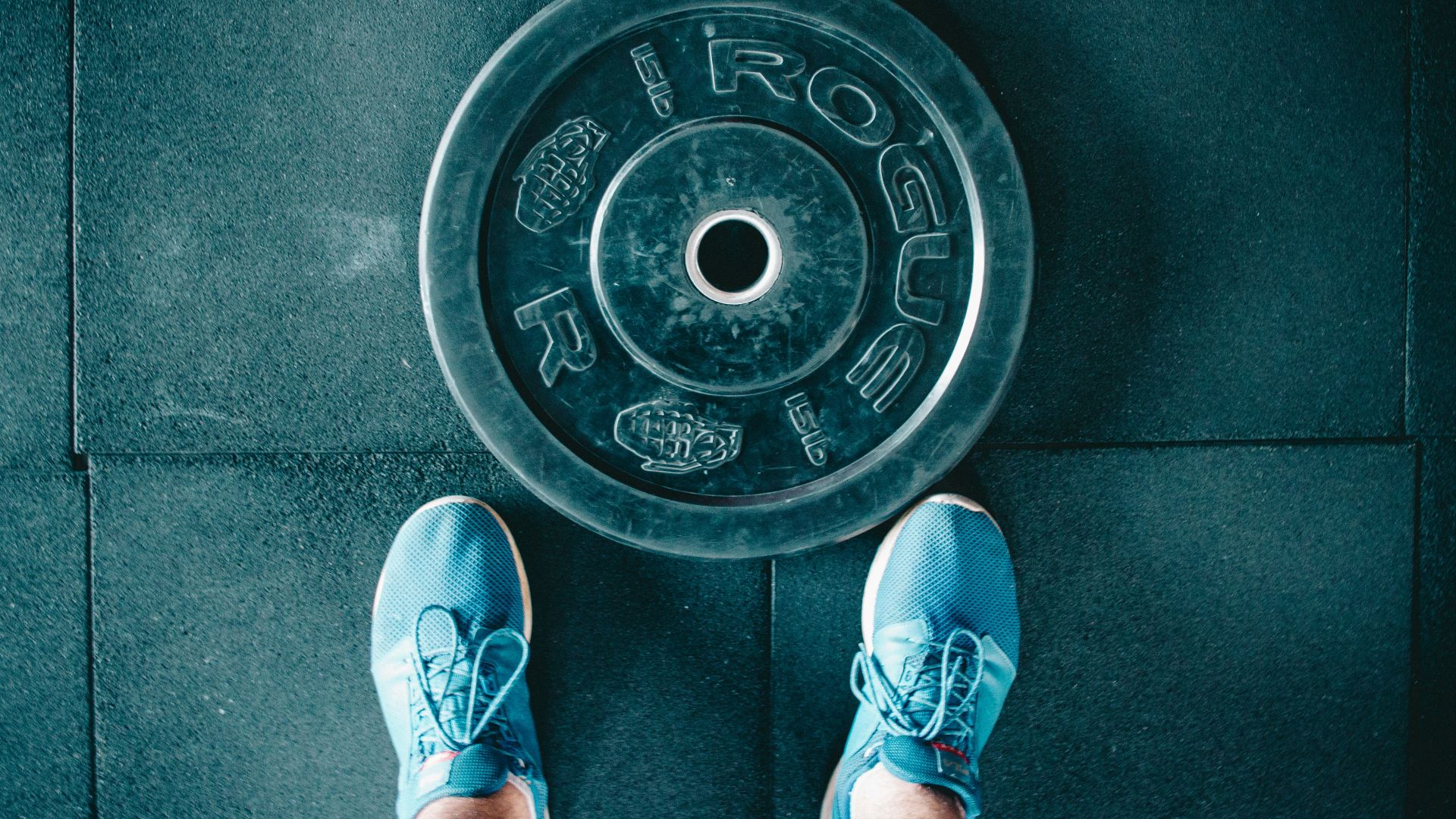person standing beside black weights