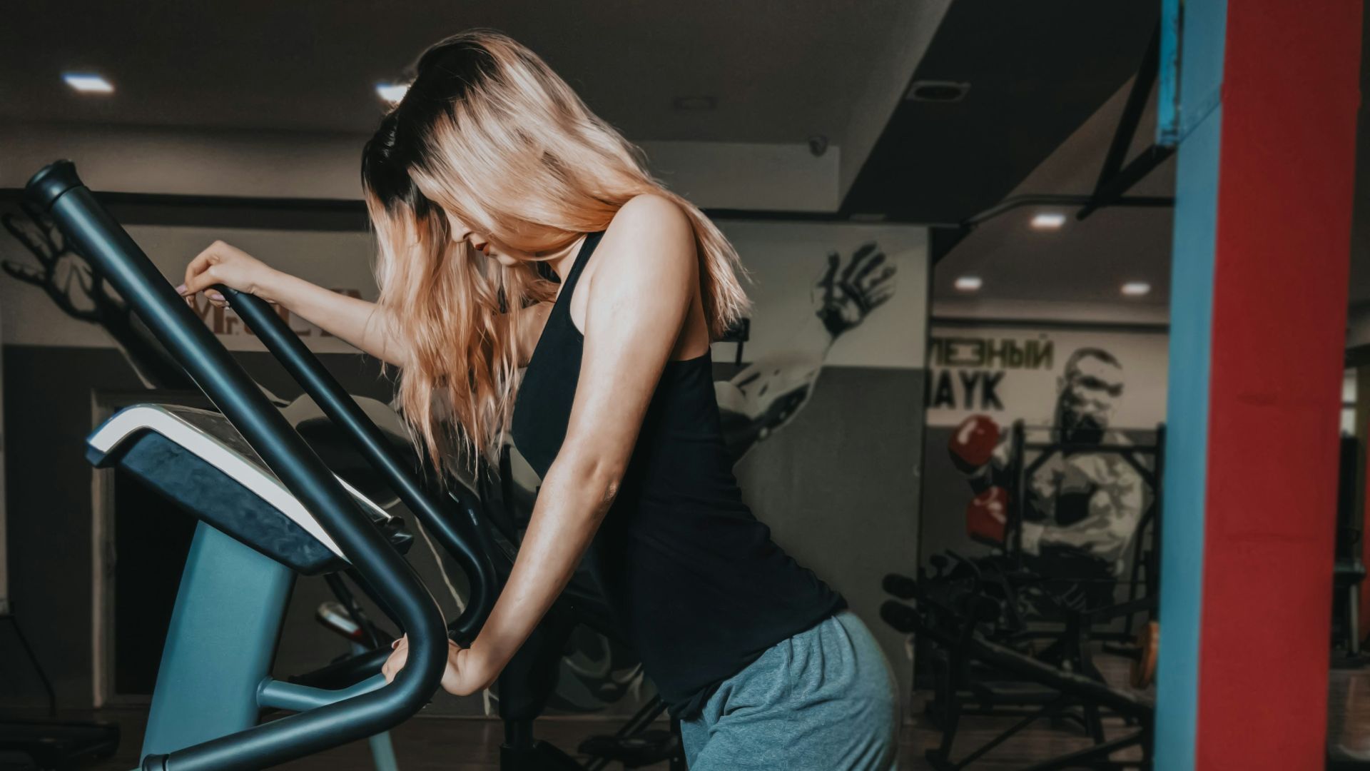 woman in black tank top and blue denim shorts standing on black metal staircase