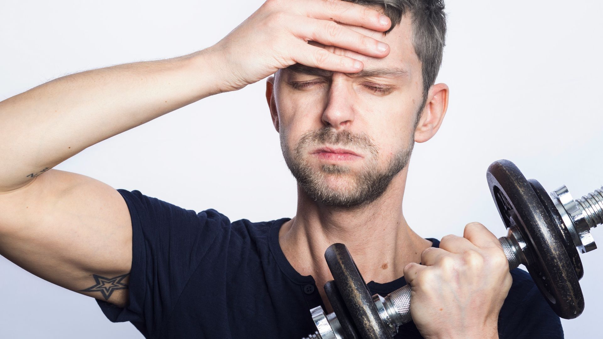 man in black crew neck t-shirt holding black dumbbell
