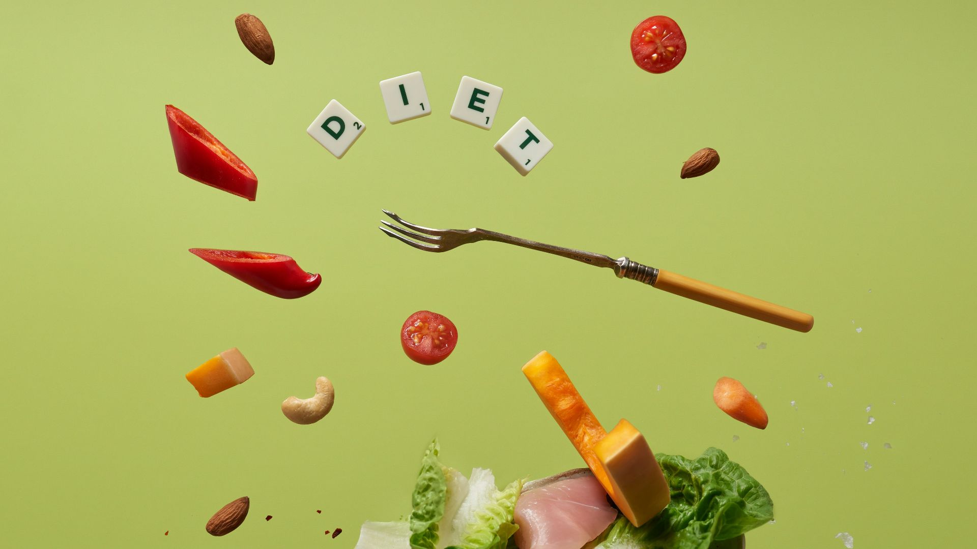 a piece of lettuce, carrots, tomatoes, and a fork are