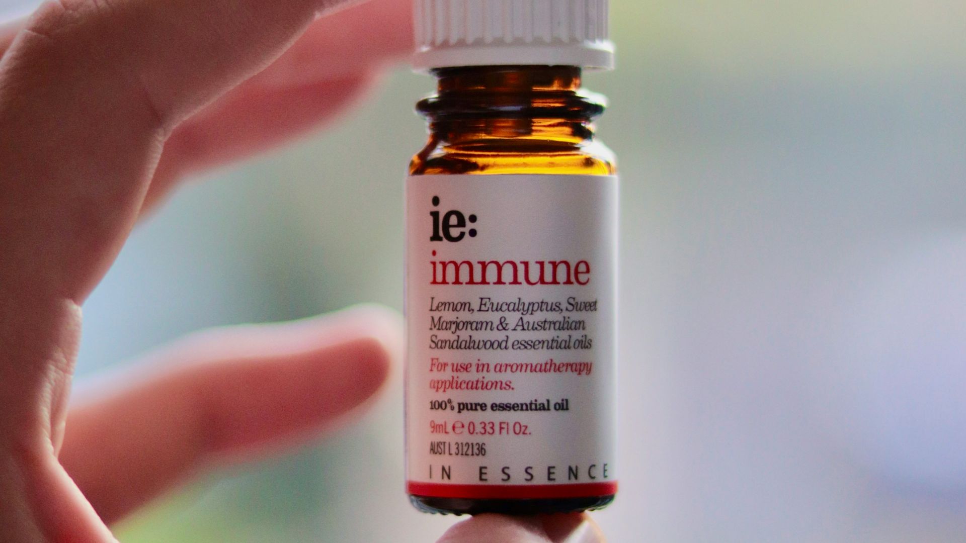 a hand holding a small bottle of vitamin oil