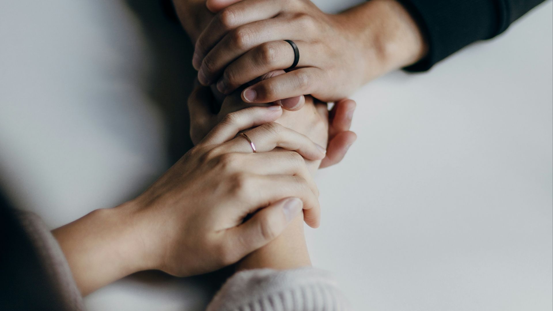 person in black long sleeve shirt holding babys feet