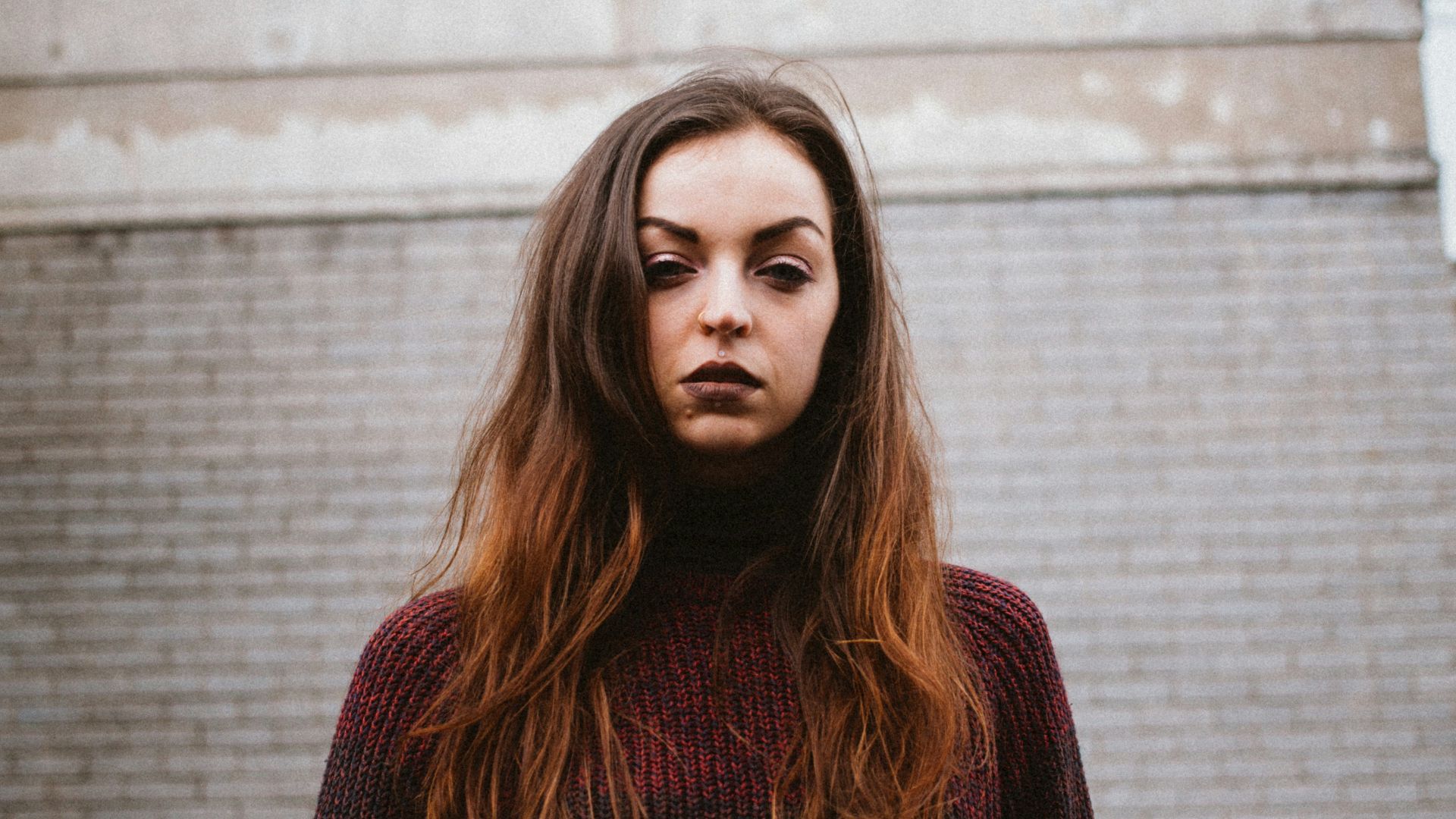 woman standing near brown building