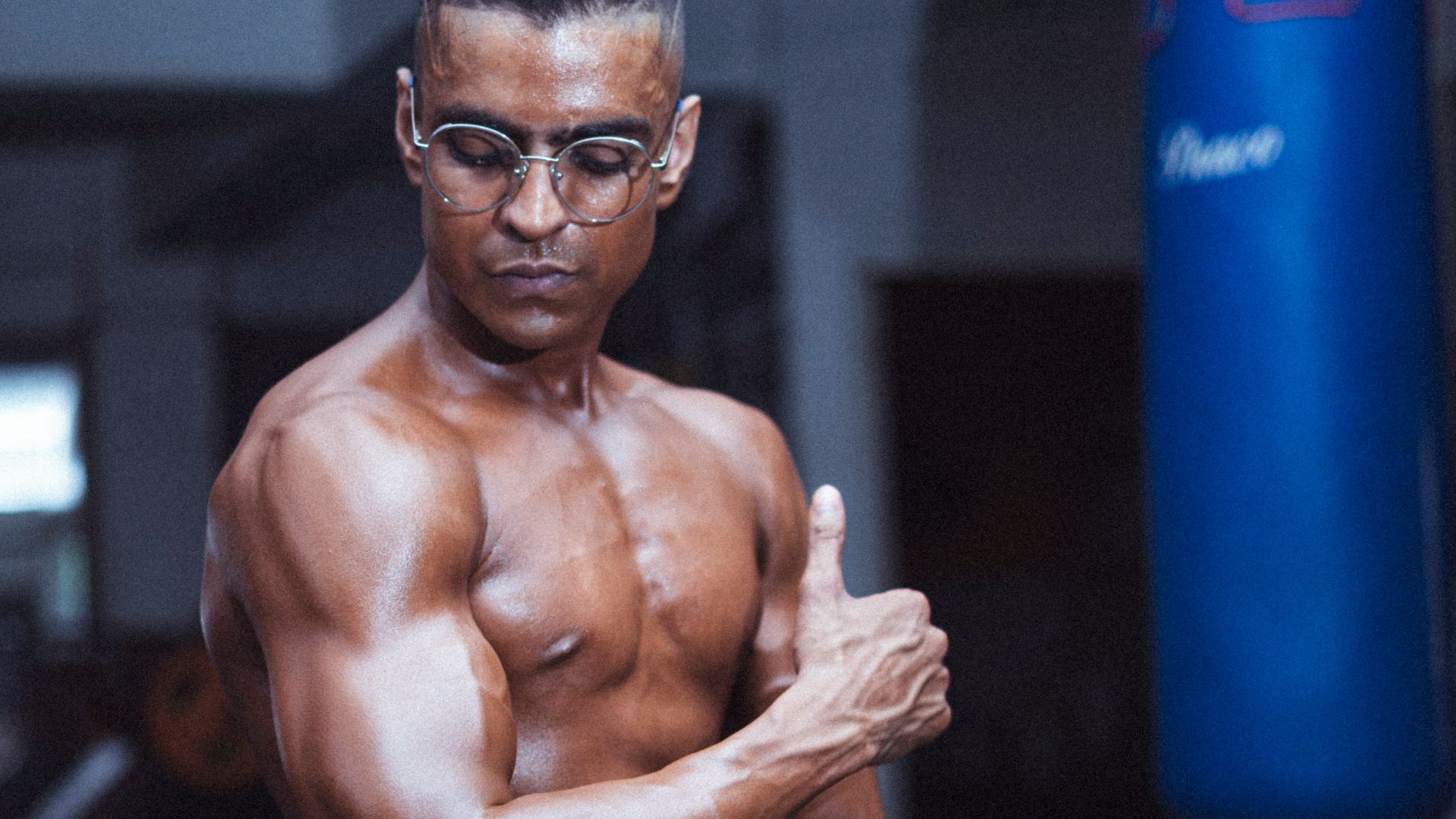 topless man in red shorts holding blue exercise ball