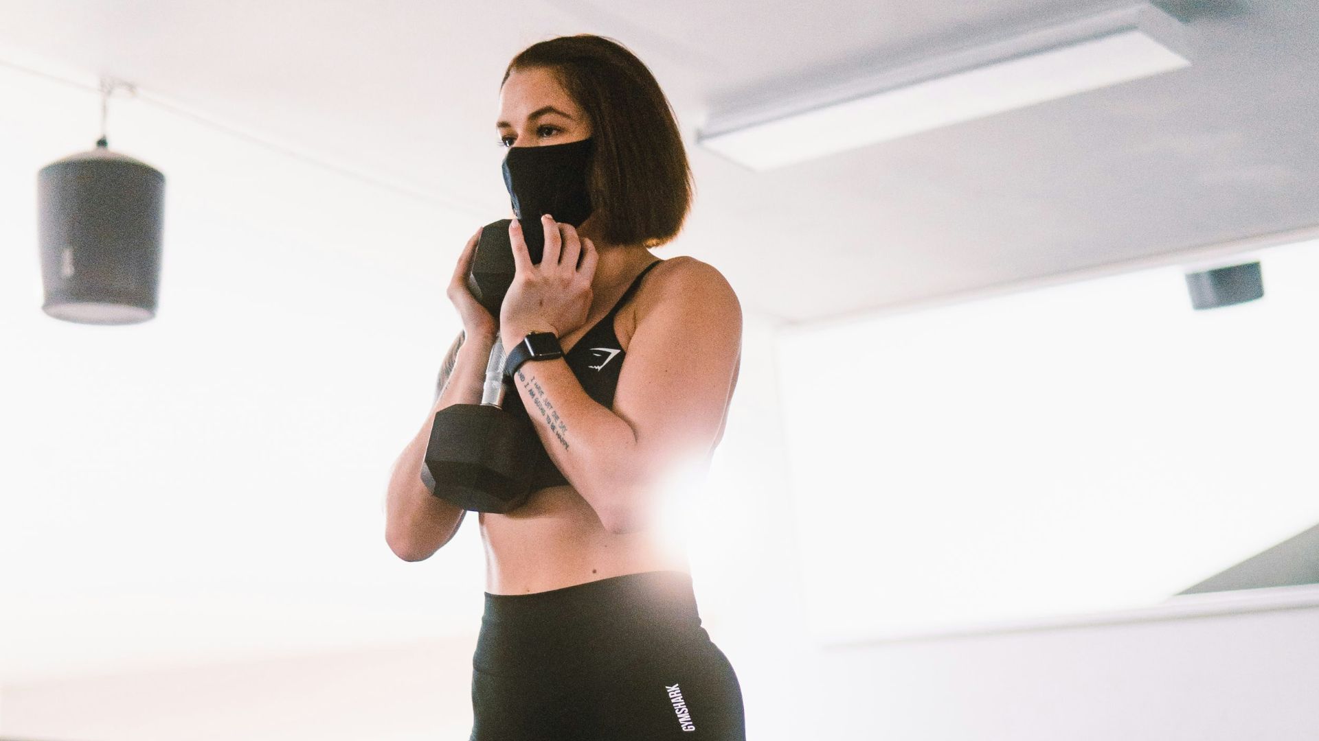 woman in black tank top and blue leggings doing yoga