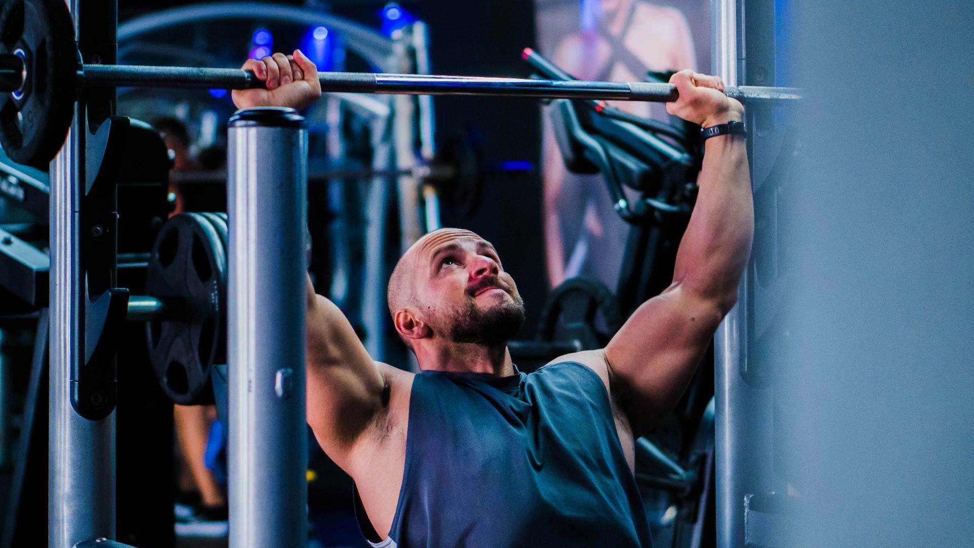 a man doing a pull up on a bar in a gym