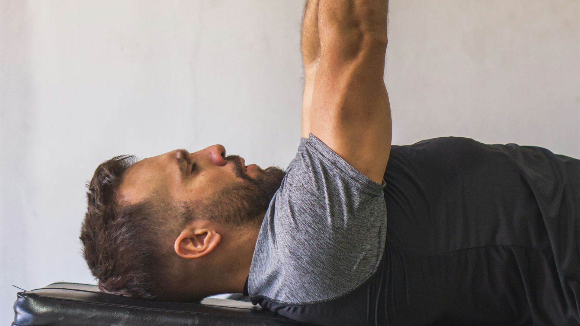 a man doing a bench press with a dumbbell