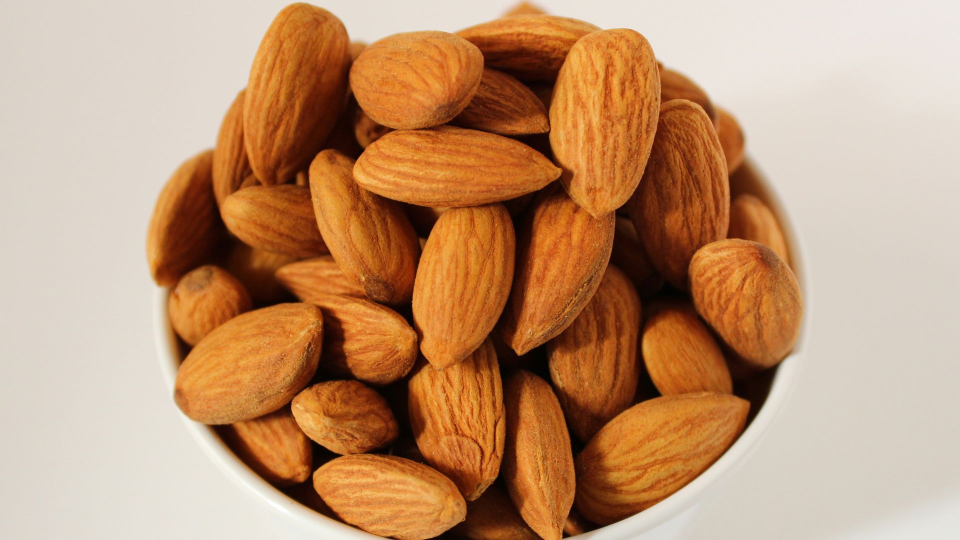 brown almond nuts on white ceramic bowl