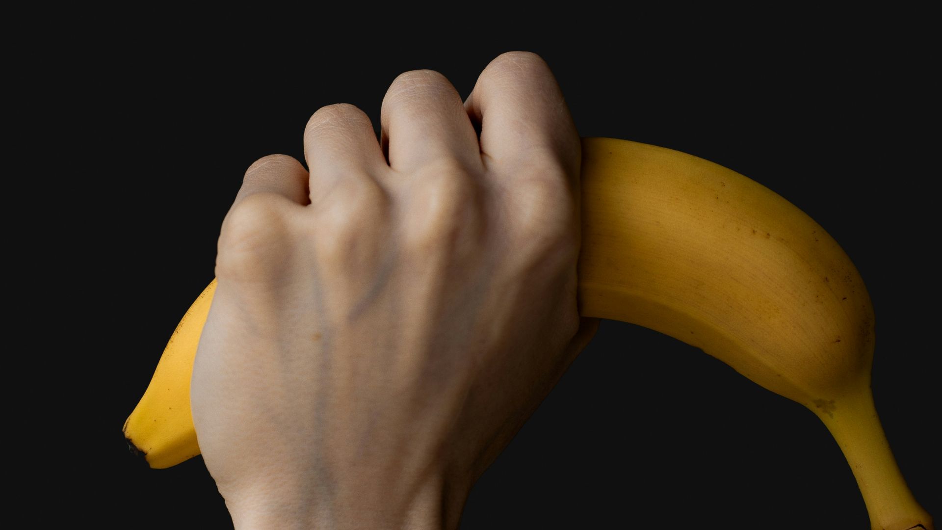 a person is holding a banana in their hand