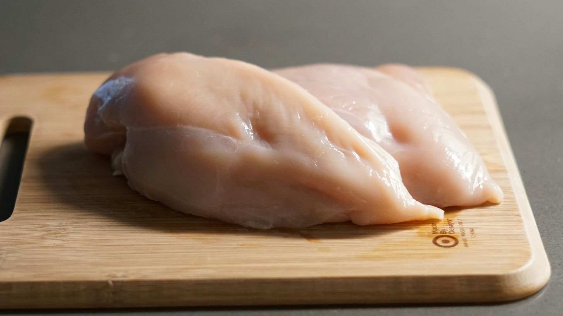 a piece of raw chicken on a cutting board