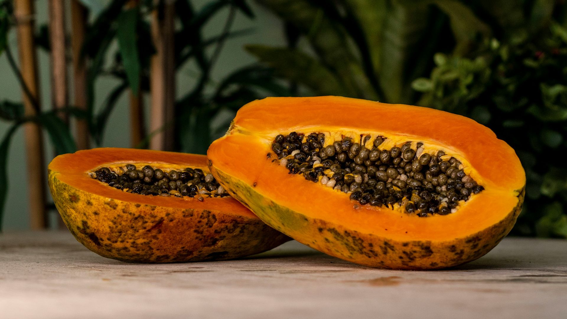 sliced papaya fruits on brown surface