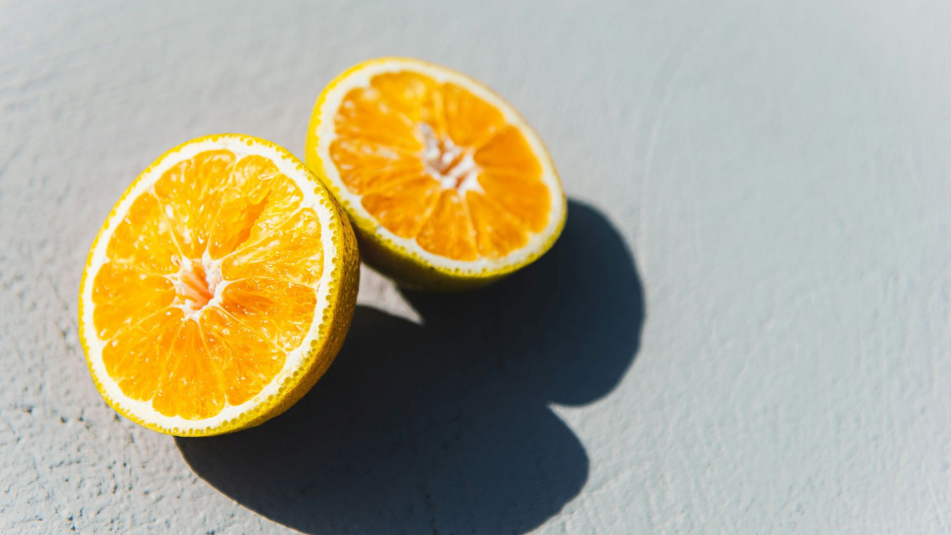 two oranges cut in half sitting on a table