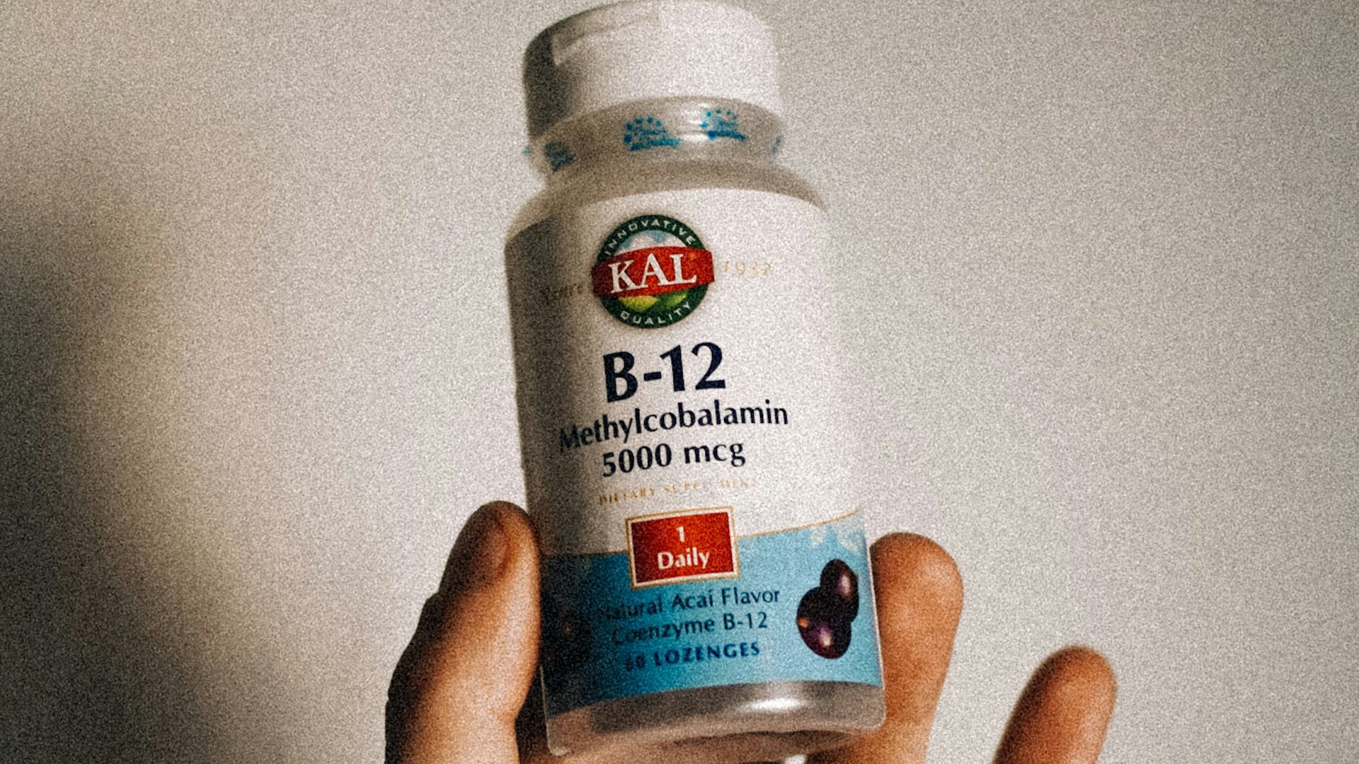 a person holding a bottle of vitamins in their hand