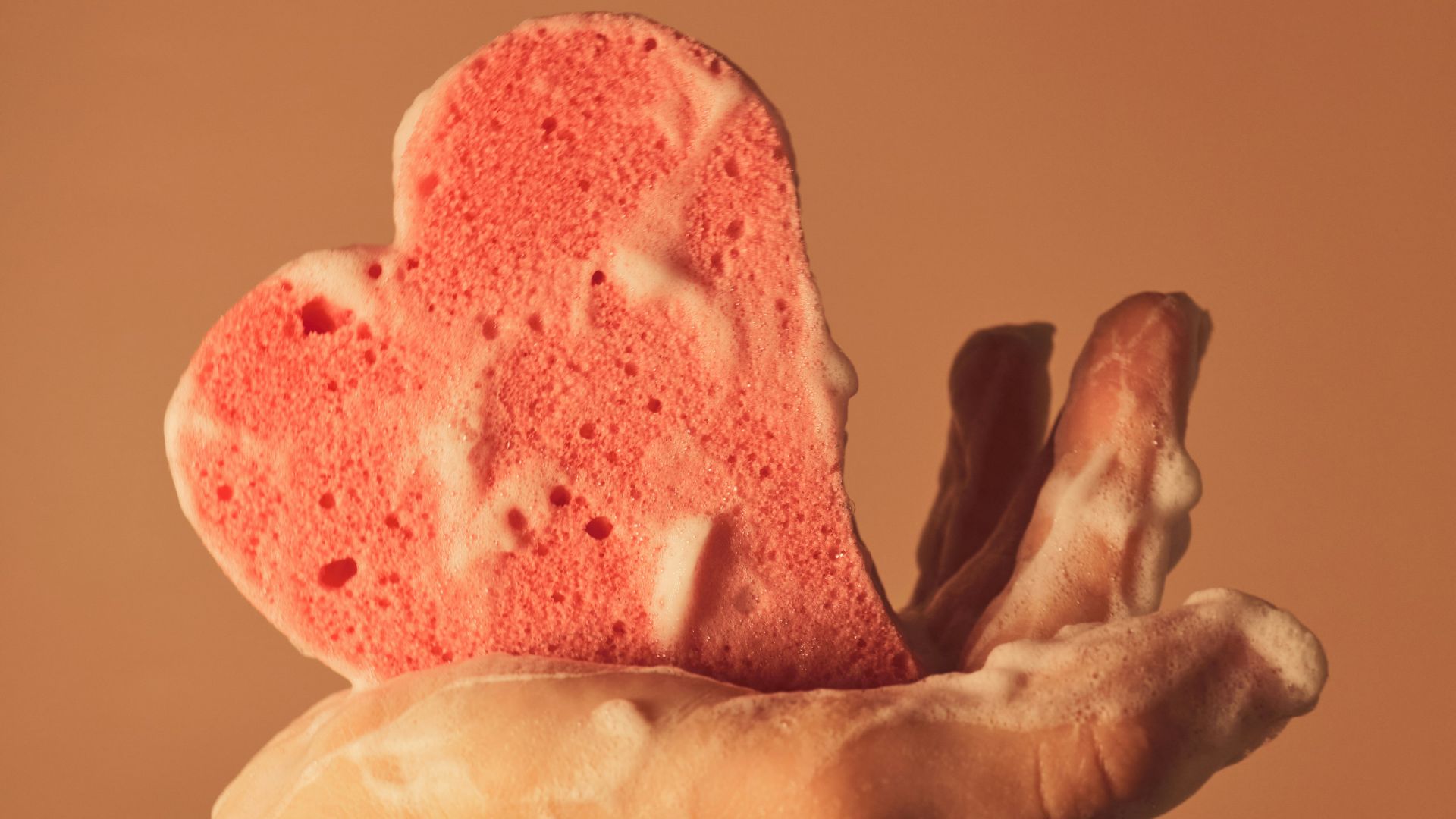 person holding pink heart shaped ornament