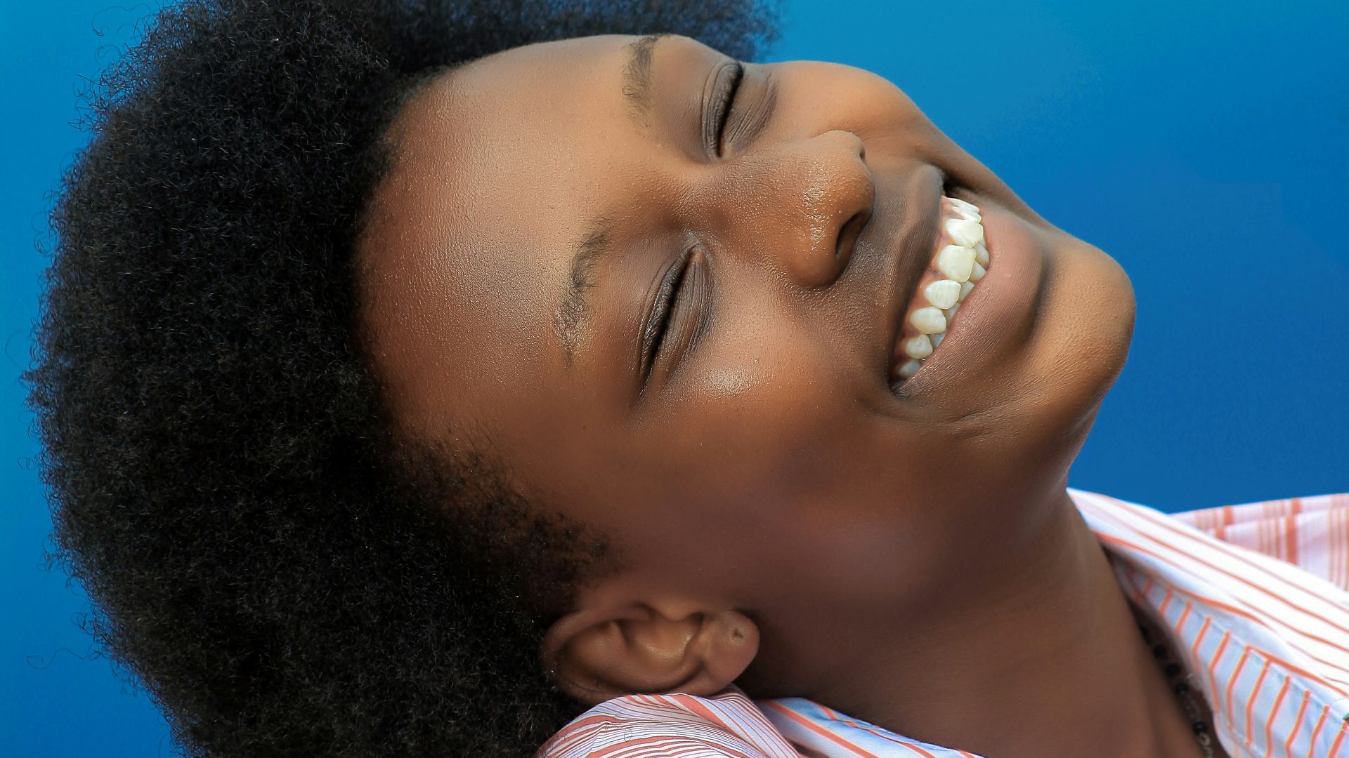smiling girl in pink and white stripe shirt