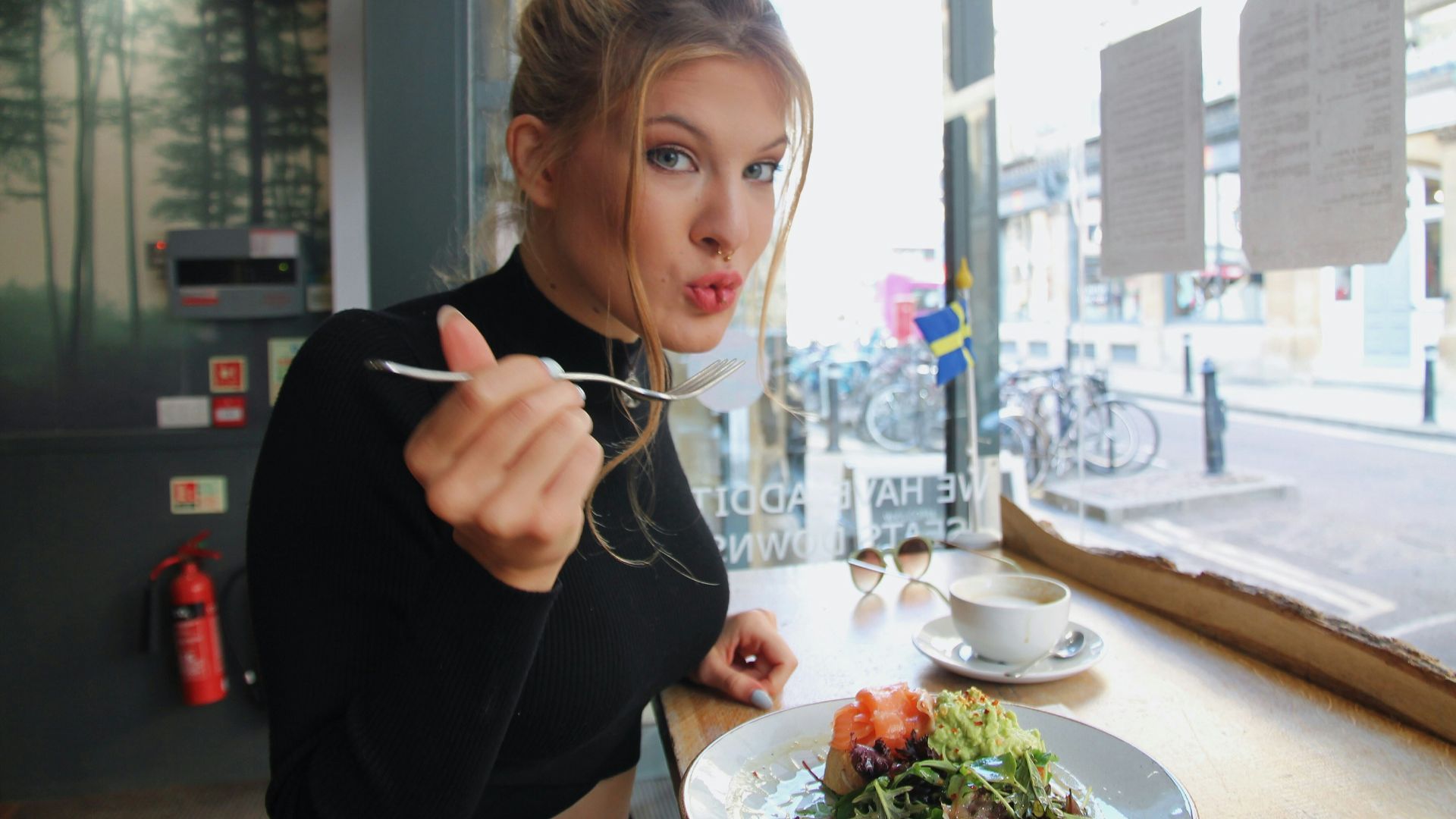 woman in black long sleeve shirt eating