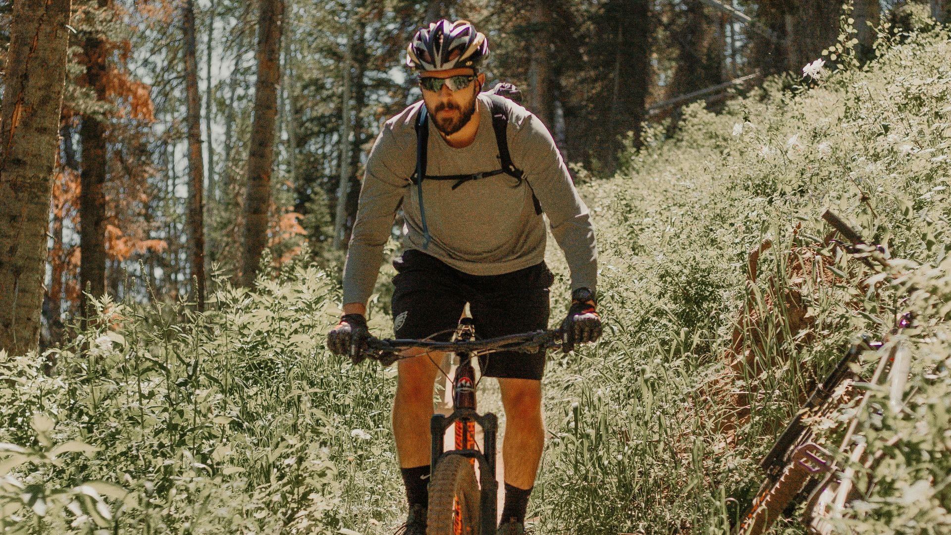 man in black jacket riding bicycle on forest during daytime