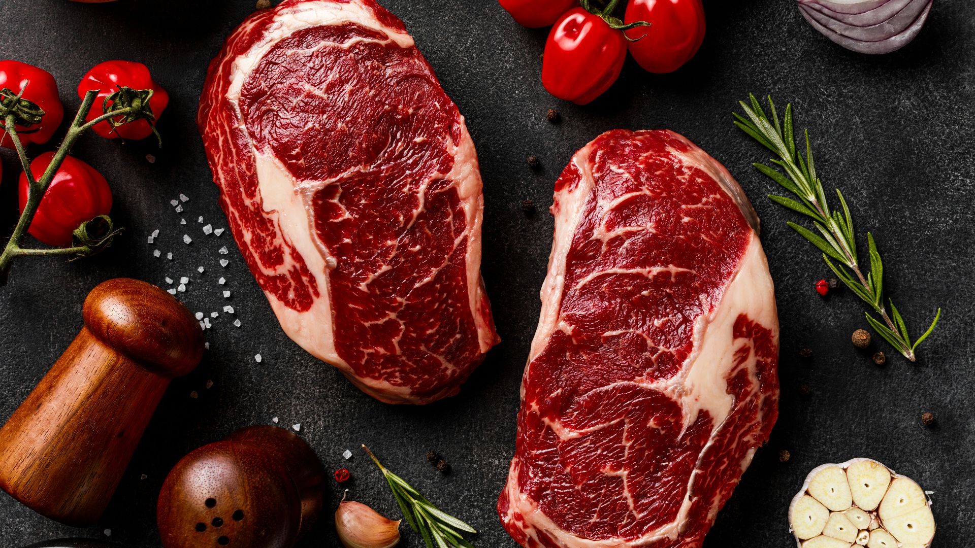 a couple of steaks sitting on top of a table