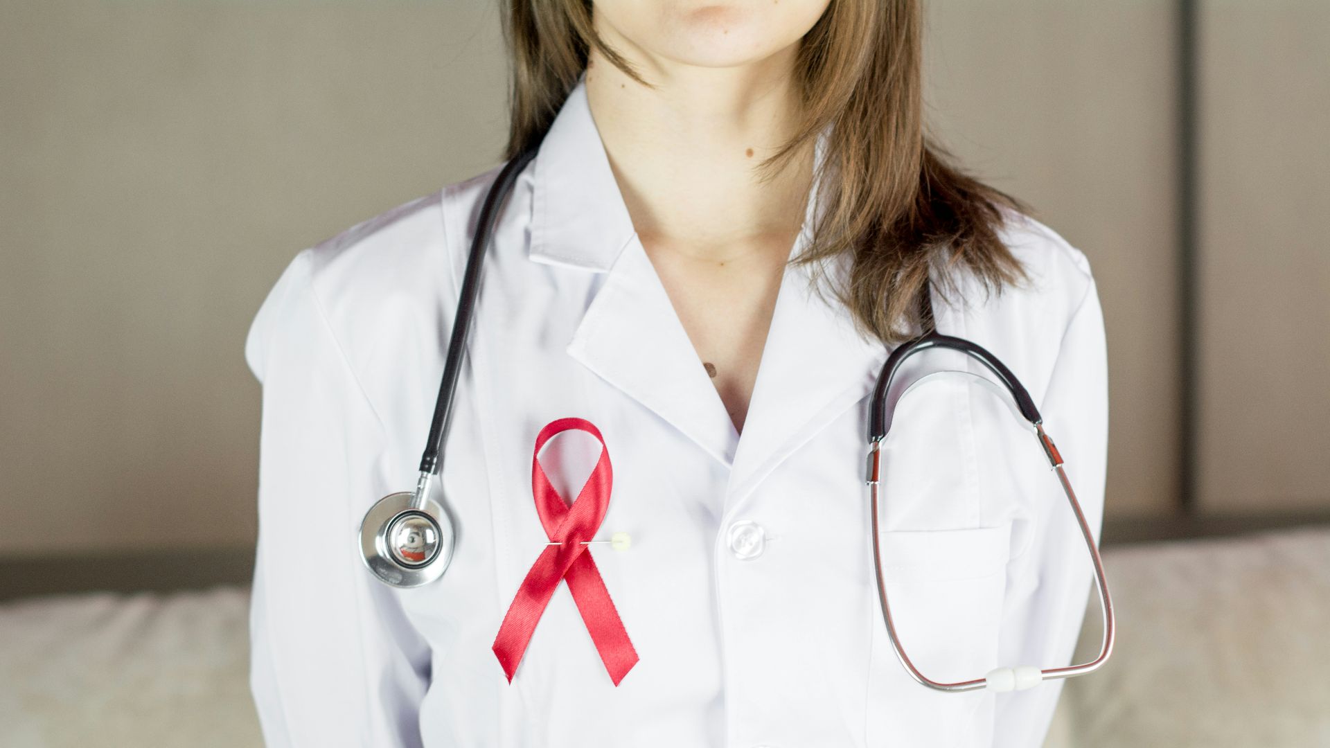 a female doctor wearing a red ribbon and a stethoscope