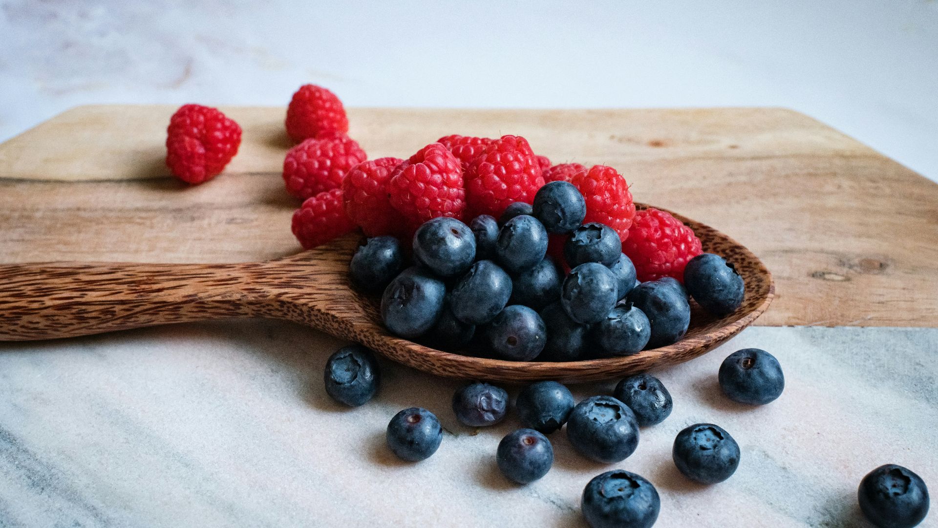 black berries on brown wooden spoon