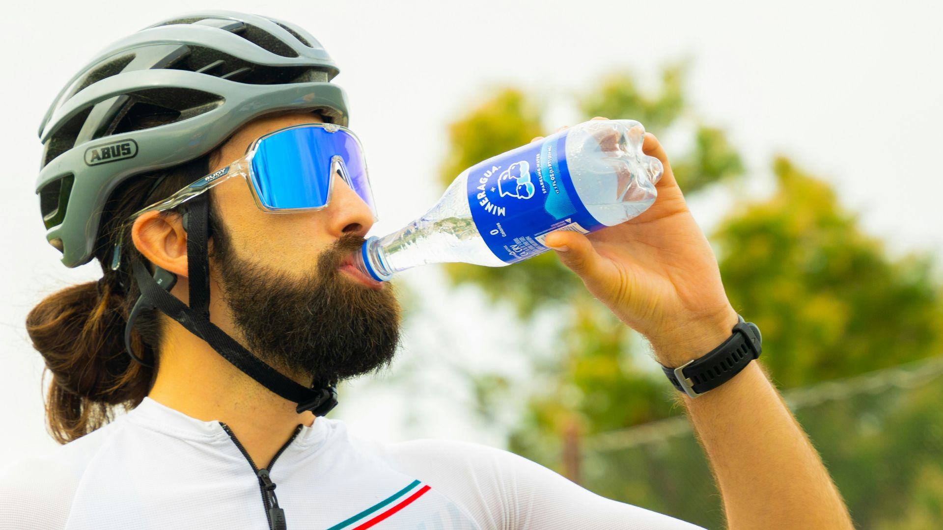 a man with a beard drinking water from a bottle