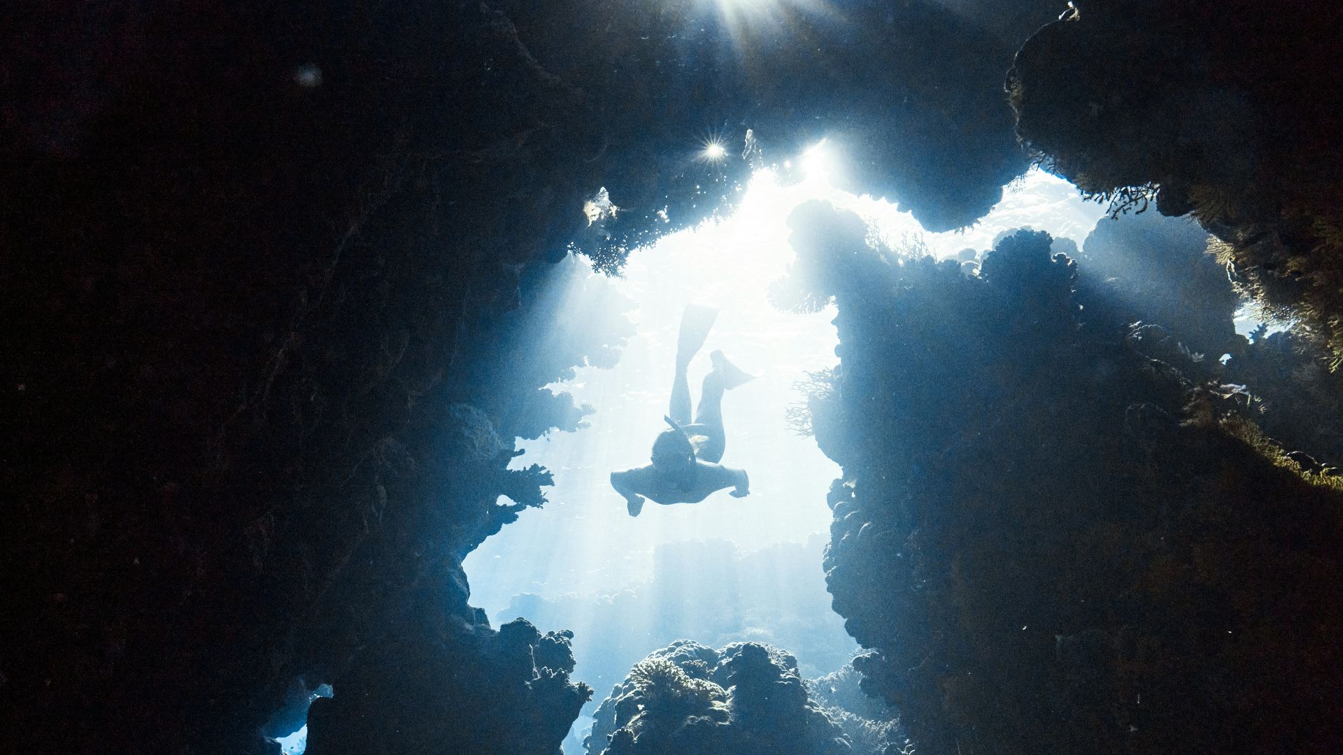 the sun shines through the water in a cave
