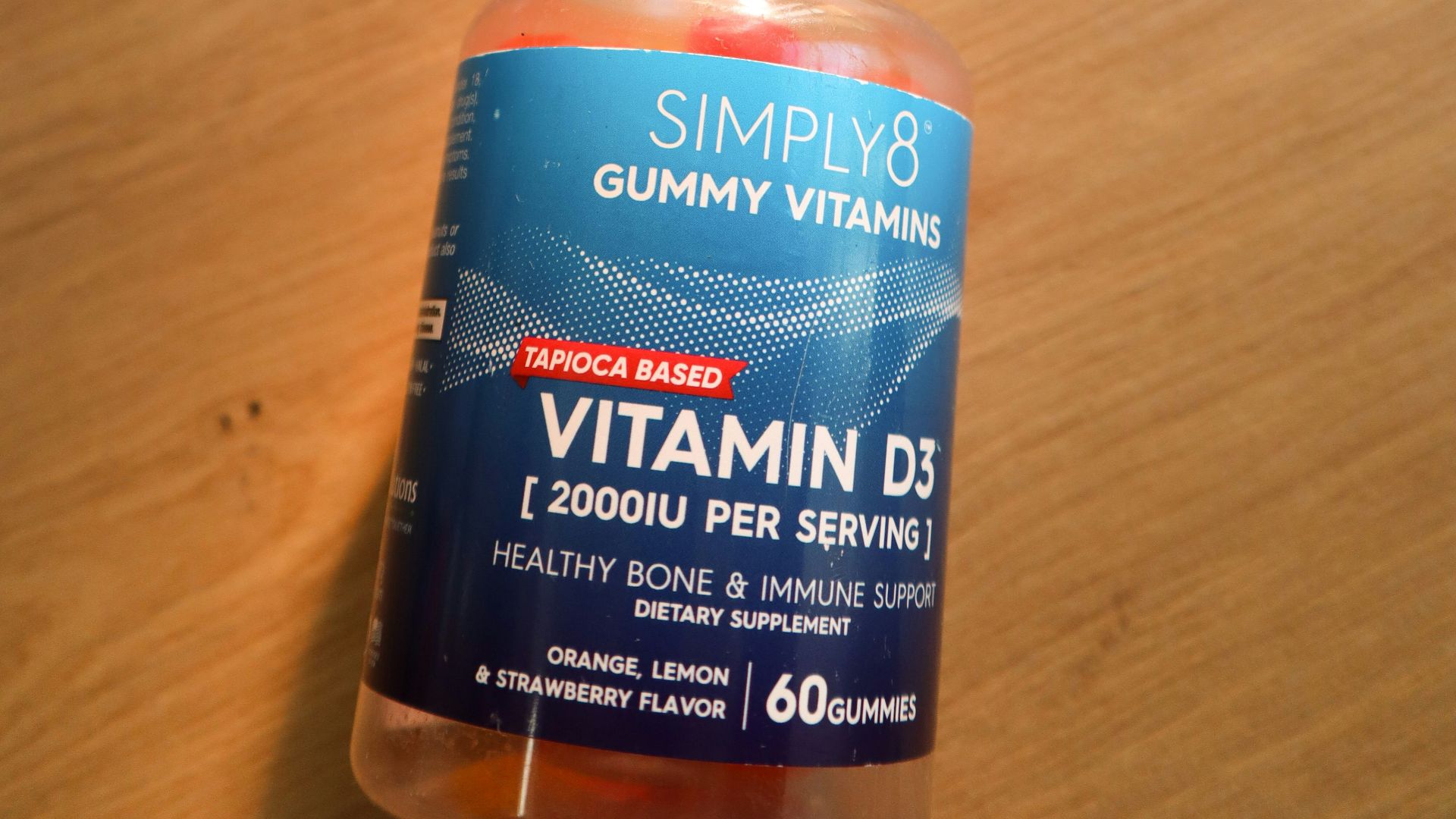a bottle of gummy vitamins sitting on top of a wooden table