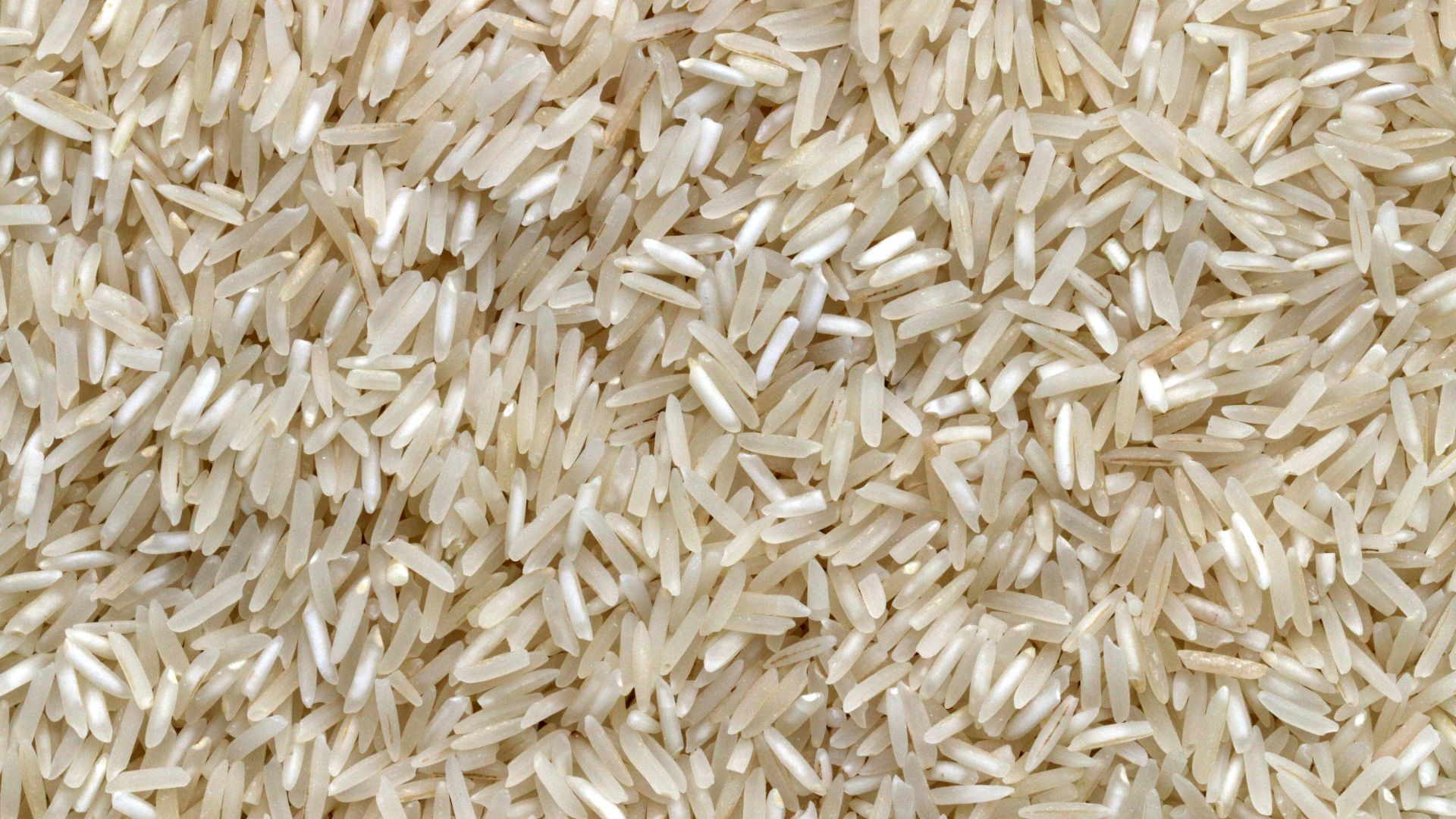 white rice grains on brown wooden table