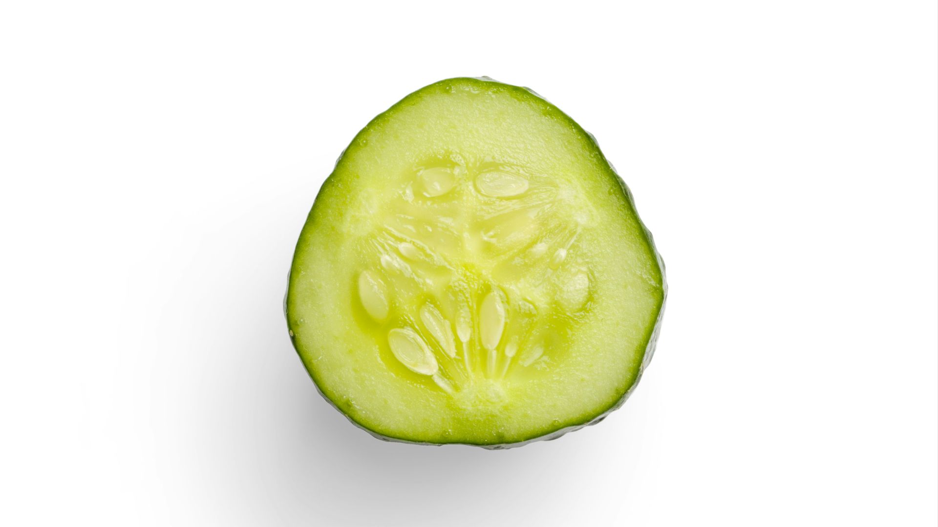 a cucumber cut in half on a white background