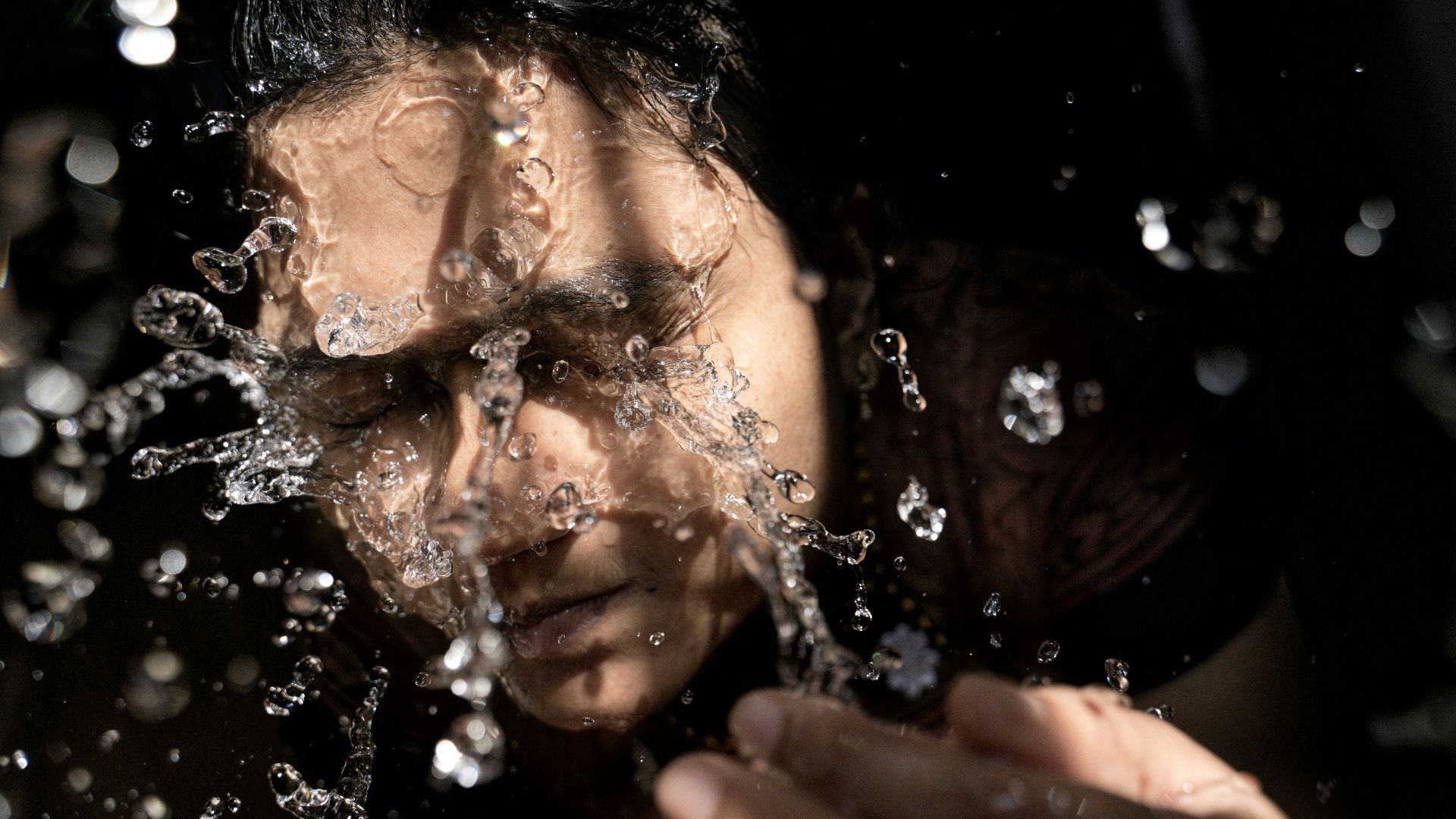 woman in black shirt with water droplets