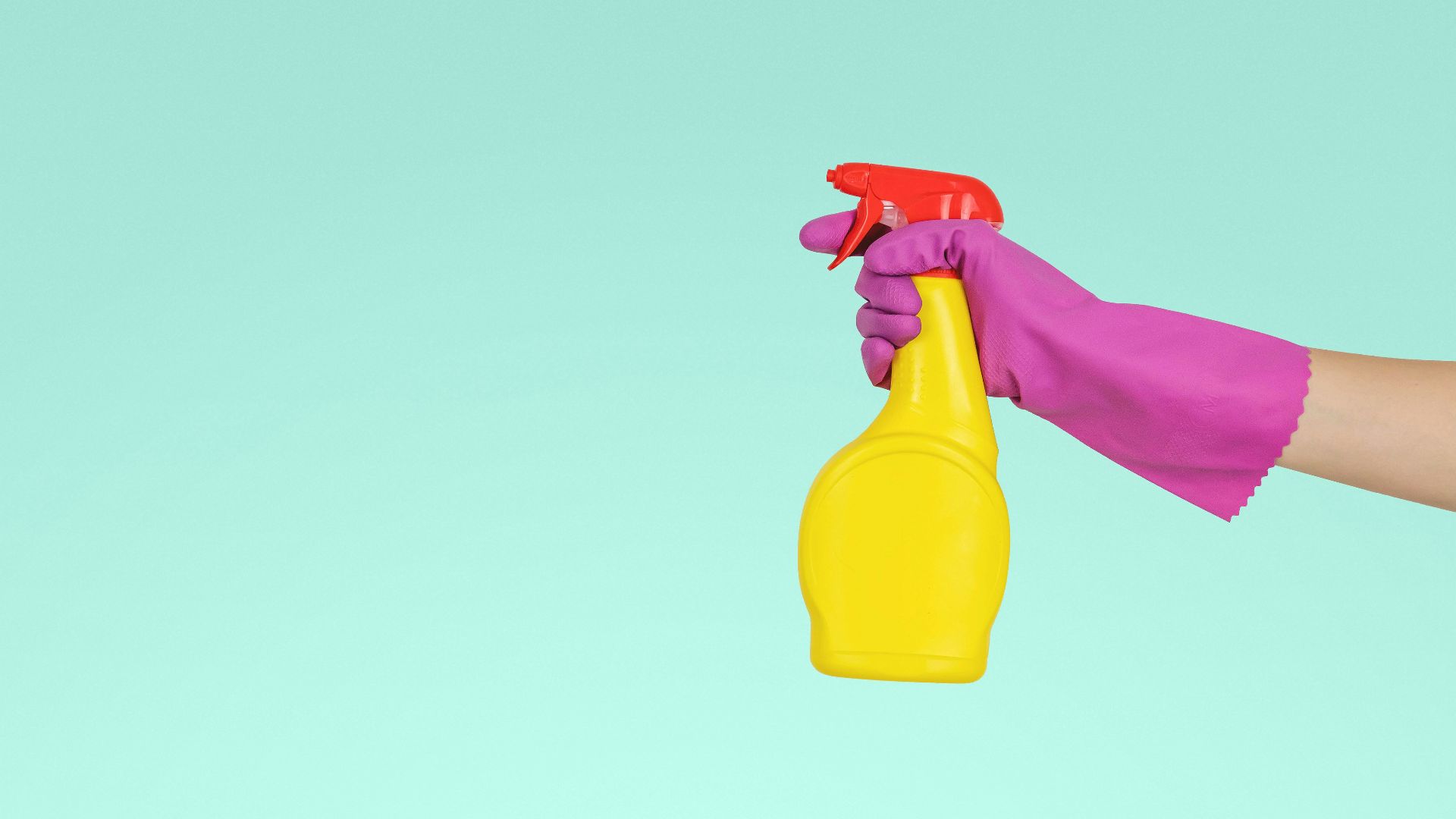 person holding yellow plastic spray bottle