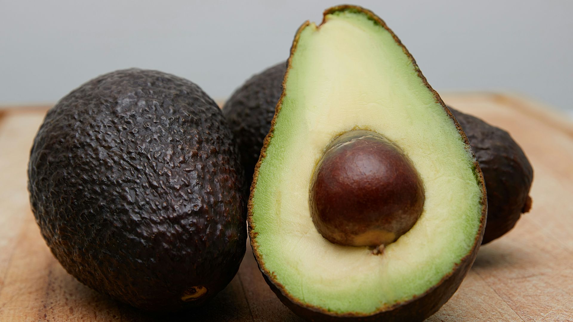 sliced avocado fruit on brown wooden table