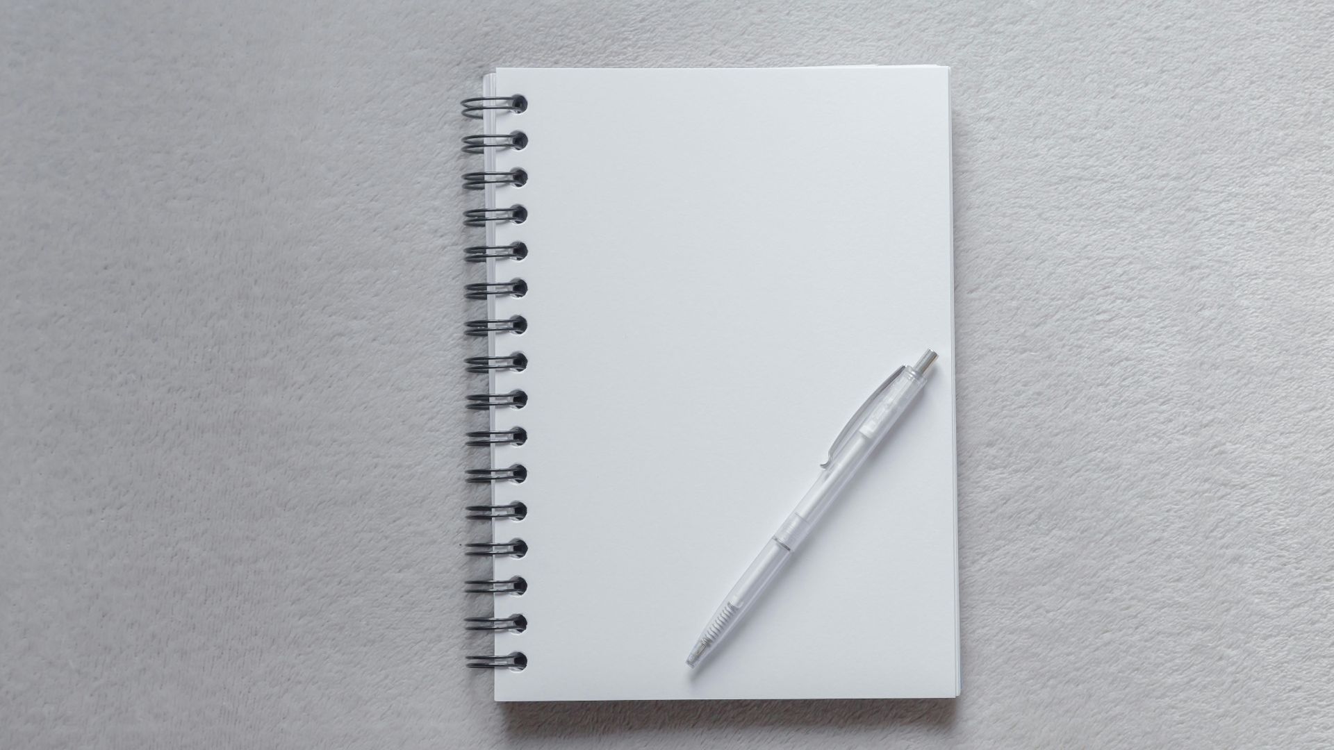 white notebook with pen on top