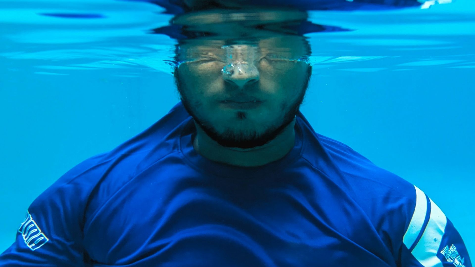 a man in a blue shirt under water