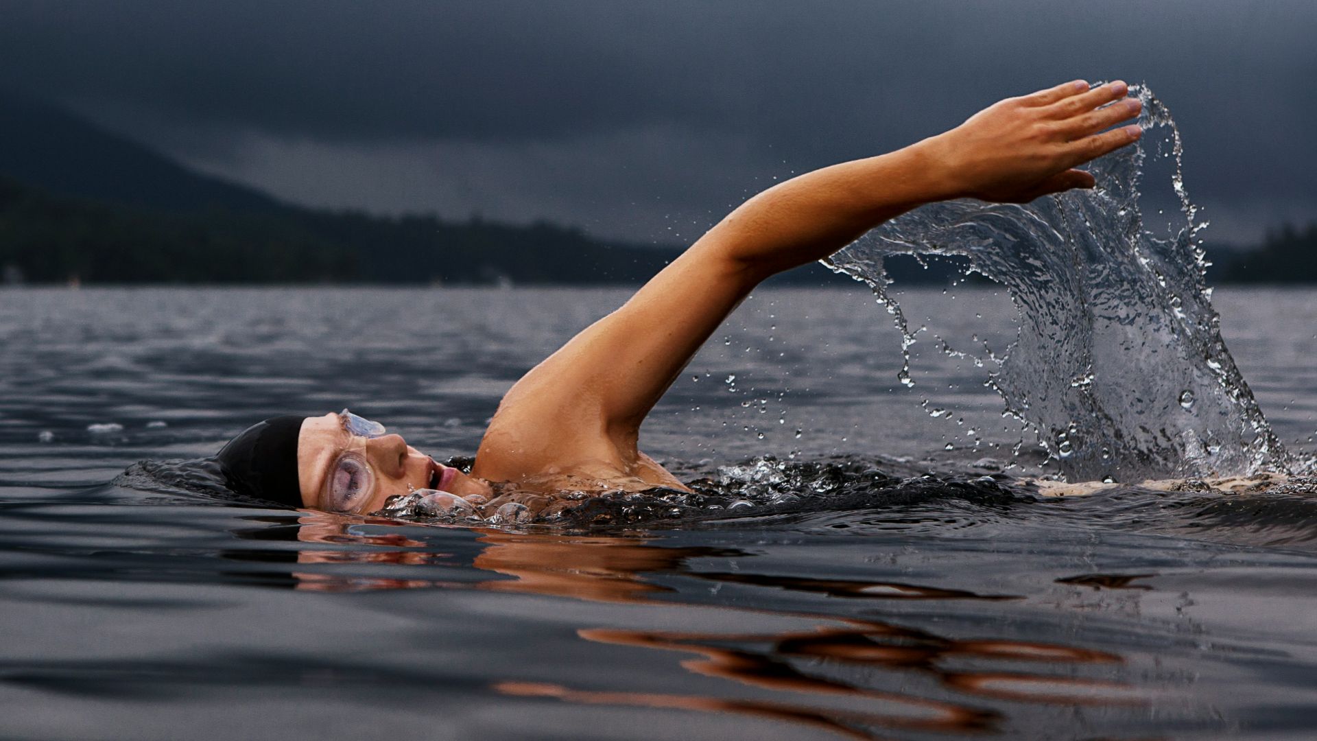 man swimming on body of water