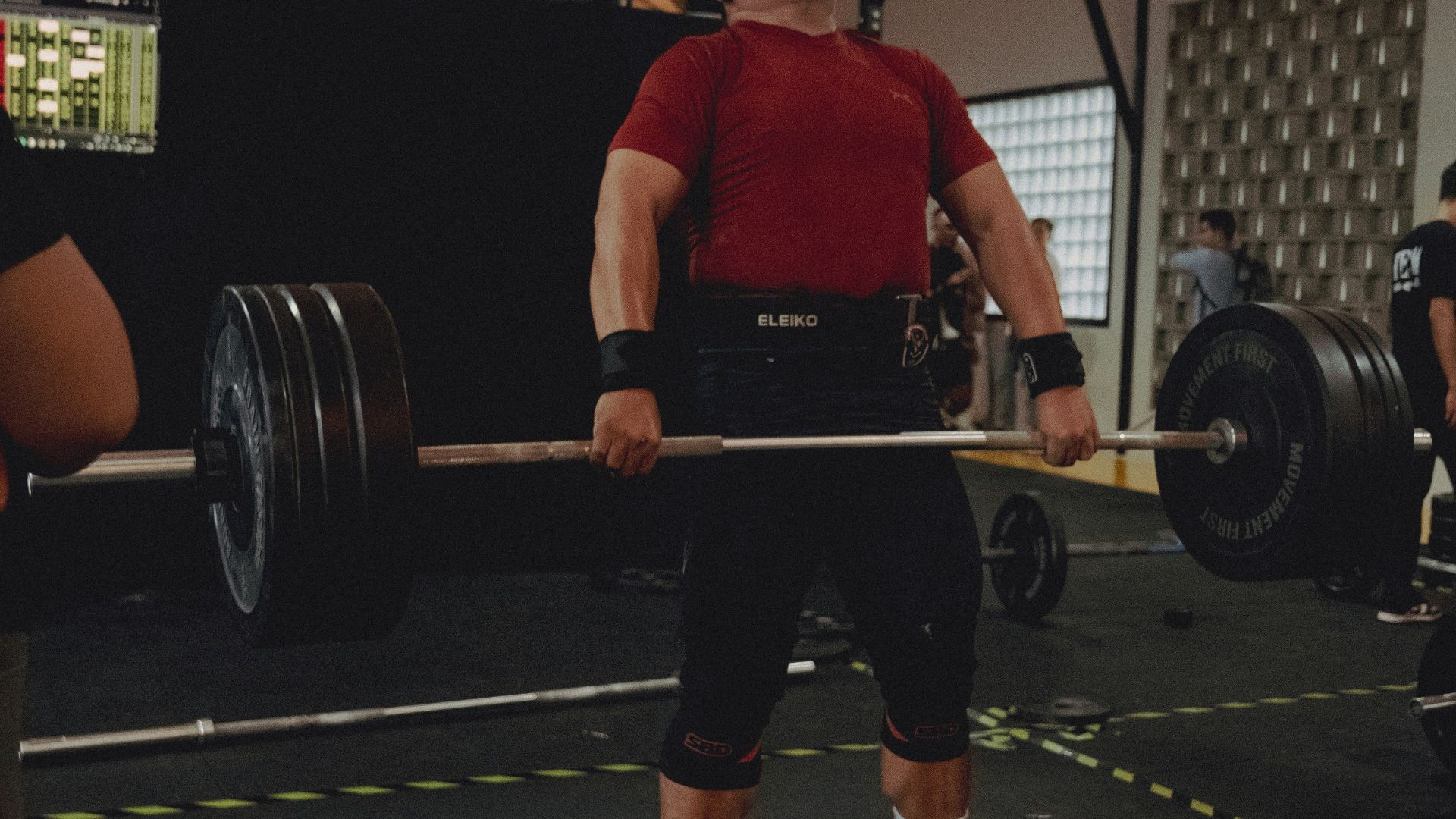 Weightlifter performs a deadlift with a heavy barbell.