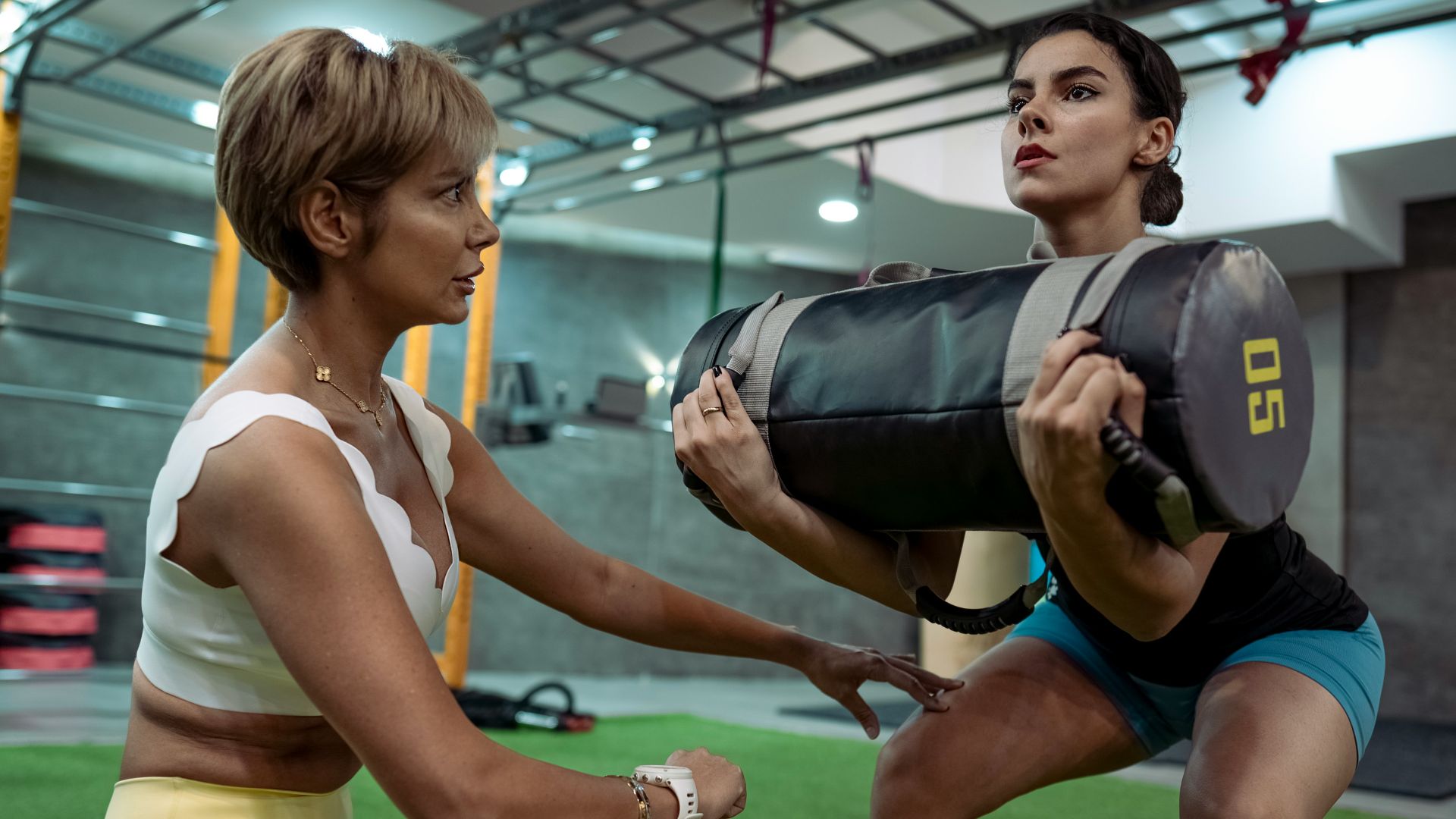A man and a woman doing squats in a gym